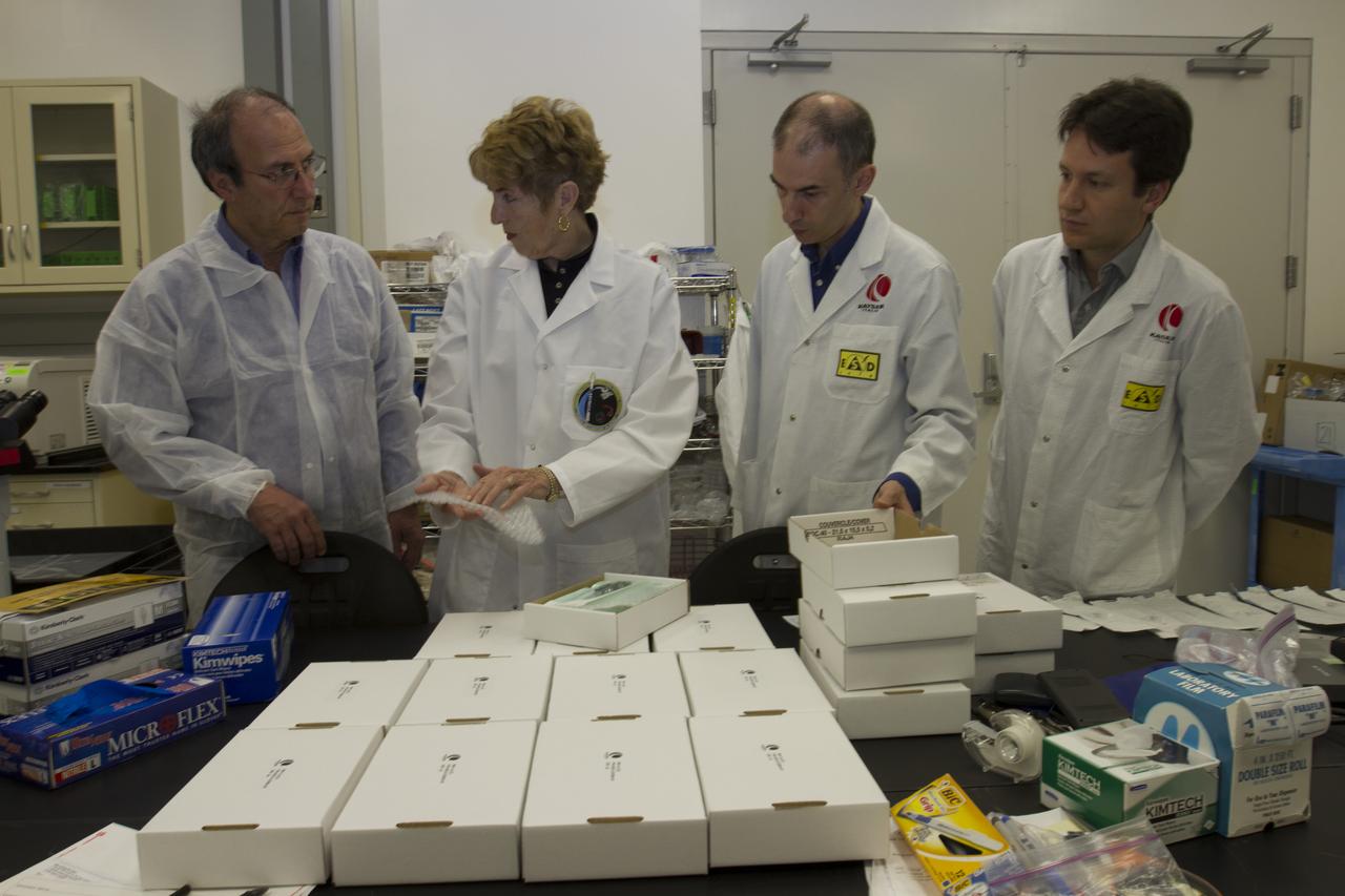 CAPE CANAVERAL, Fla. - Researcher and former NASA payload specialist Millie Hughes-Fulford, of the Hughes-Fulford Laboratory, San Francisco, Calif., accepts the European Space Agency ESA T-cell experiment flight units being handed over in a Space Station Processing Facility laboratory at NASA's Kennedy Space Center in Florida. From left are Raimondo Fortezza of ESA, Hughes-Fulford, and Pier Luigi Ganga and Fabio Creati of Kayser Italia, manufacturer of the hardware. The immunology experiment will launch on SpaceX-3 and focus on the effects of microgravity on early T-cell signaling pathways. Current work aims to identify and compare the gene expression of microRNAs miRNAs during T-cell activation under normal gravity and in microgravity, and compare those patterns to changes seen in aging populations. The experiment will be the first flown on SpaceX funded by the National Institutes of Health. Dr. Hughes-Fulford flew aboard space shuttle mission STS-40 in June 1991, the first Spacelab mission dedicated to biomedical studies. For more information on the T-cell experiment, visit http://hughesfulfordlab.com and http://www.nasa.gov/ames/research/space-biosciences/t-cell-activation-in-aging-spacex-3/. Photo credit: NASA/Cory Huston