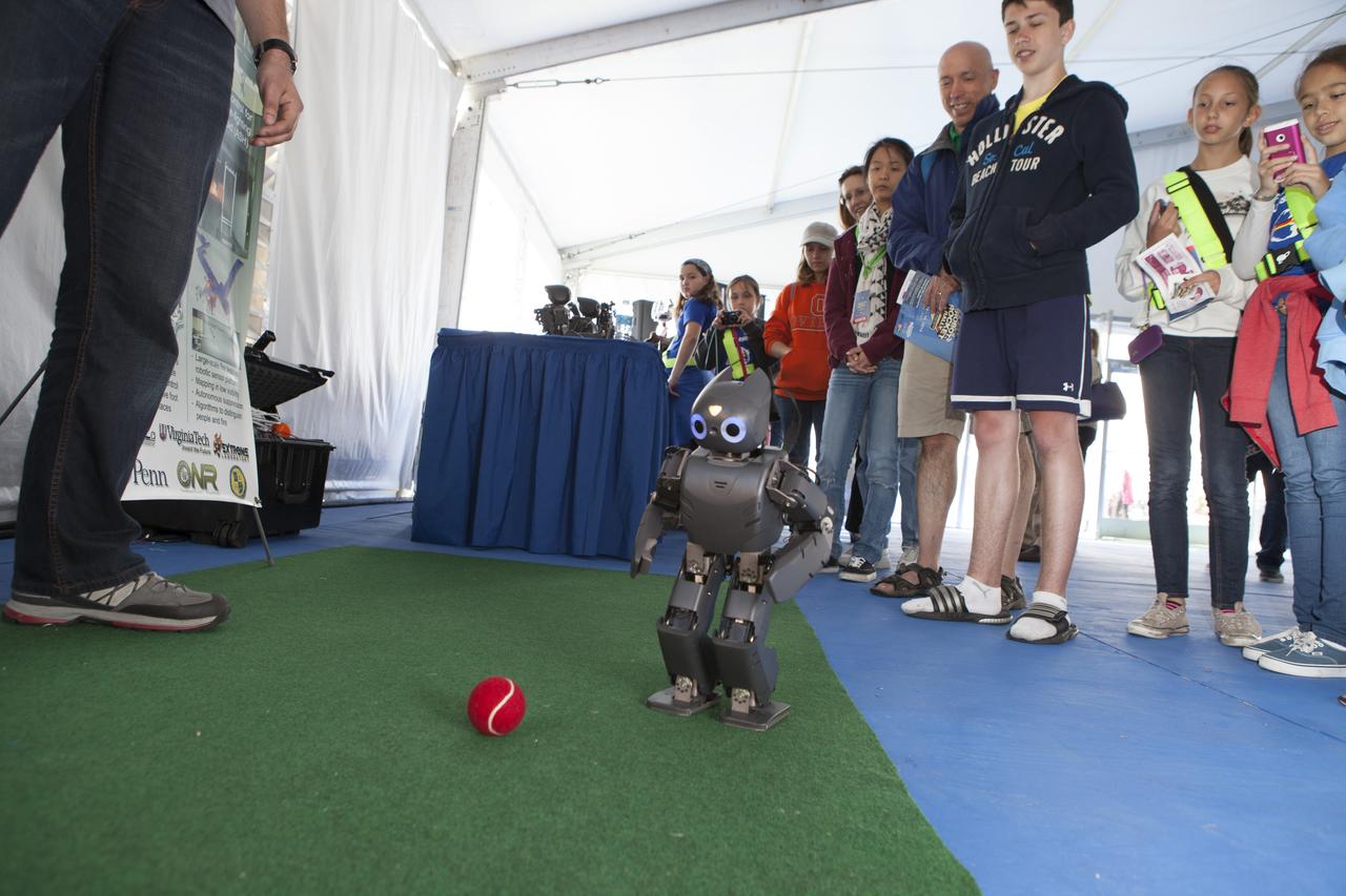 CAPE CANAVERAL, Fla. – Students gather to watch as a DARwin-OP miniature humanoid robot from Virginia Tech Robotics demonstrates its soccer abilities at the Robot Rocket Rally. The three-day event at Florida's Kennedy Space Center Visitor Complex is highlighted by exhibits, games and demonstrations of a variety of robots, with exhibitors ranging from school robotics clubs to veteran NASA scientists and engineers. Photo credit: NASA/Kim Shiflett