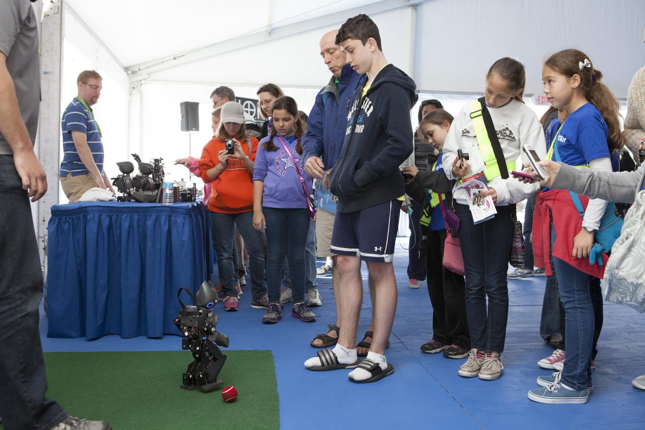 CAPE CANAVERAL, Fla. – Students gather to watch as a DARwin-OP miniature humanoid robot from Virginia Tech Robotics demonstrates its soccer abilities at the Robot Rocket Rally. The three-day event at Florida's Kennedy Space Center Visitor Complex is highlighted by exhibits, games and demonstrations of a variety of robots, with exhibitors ranging from school robotics clubs to veteran NASA scientists and engineers. Photo credit: NASA/Kim Shiflett