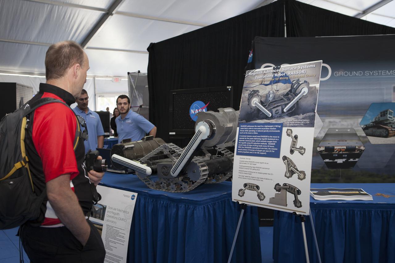 CAPE CANAVERAL, Fla. – A visitor to the Robot Rocket Rally takes an up-close look at RASSOR, a robotic miner developed by NASA Kennedy Space Center's Swamp Works. The three-day event at Florida's Kennedy Space Center Visitor Complex is highlighted by exhibits, games and demonstrations of a variety of robots, with exhibitors ranging from school robotics clubs to veteran NASA scientists and engineers. Photo credit: NASA/Kim Shiflett