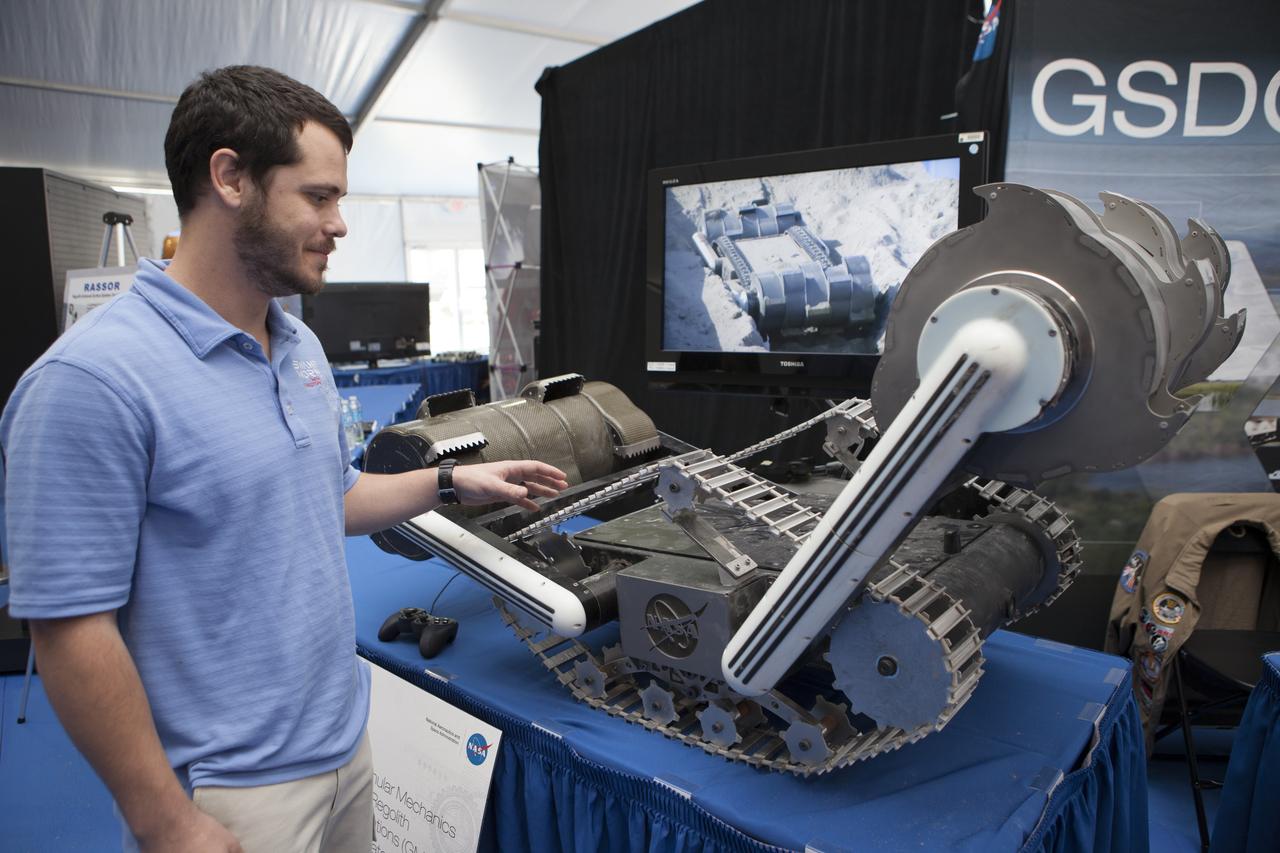 CAPE CANAVERAL, Fla. – Andrew Nick of Kennedy Space Center's Swamp Works shows off RASSOR, a robotic miner, at the Robot Rocket Rally. The three-day event at Florida's Kennedy Space Center Visitor Complex is highlighted by exhibits, games and demonstrations of a variety of robots, with exhibitors ranging from school robotics clubs to veteran NASA scientists and engineers. Photo credit: NASA/Kim Shiflett