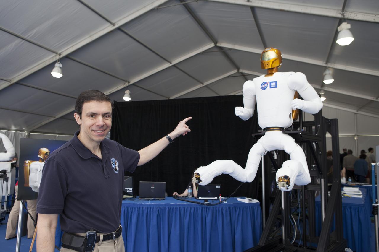 CAPE CANAVERAL, Fla. – Ron Diftler of NASA's Johnson Space Center in Houston demonstrates the leg movements of Robonaut 2 during the Robot Rocket Rally. The three-day event at Florida's Kennedy Space Center Visitor Complex is highlighted by exhibits, games and demonstrations of a variety of robots, with exhibitors ranging from school robotics clubs to veteran NASA scientists and engineers. Photo credit: NASA/Kim Shiflett