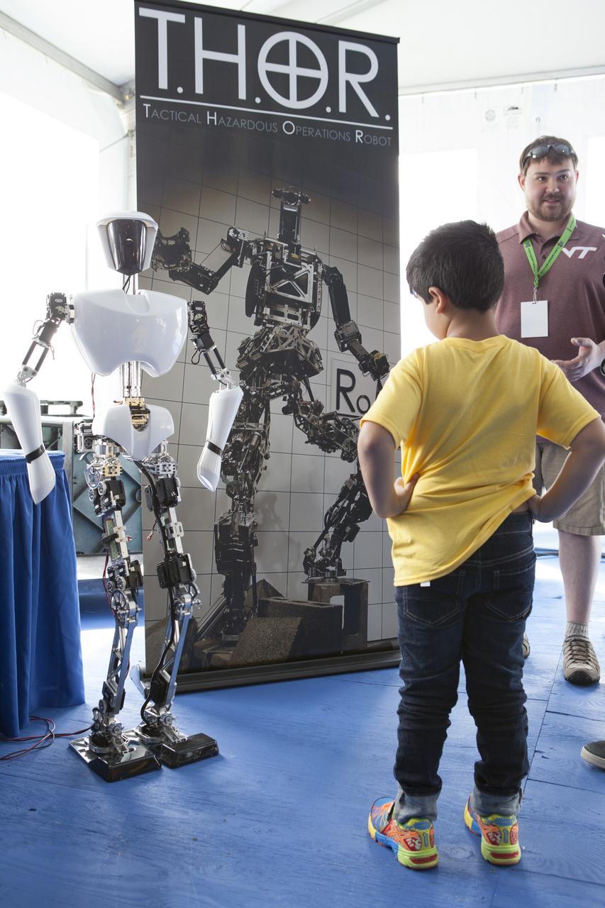 CAPE CANAVERAL, Fla. – A child gets an up-close look at Charli, an autonomous walking robot developed by Virginia Tech Robotics, during the Robot Rocket Rally. The three-day event at Florida's Kennedy Space Center Visitor Complex is highlighted by exhibits, games and demonstrations of a variety of robots, with exhibitors ranging from school robotics clubs to veteran NASA scientists and engineers. Photo credit: NASA/Kim Shiflett