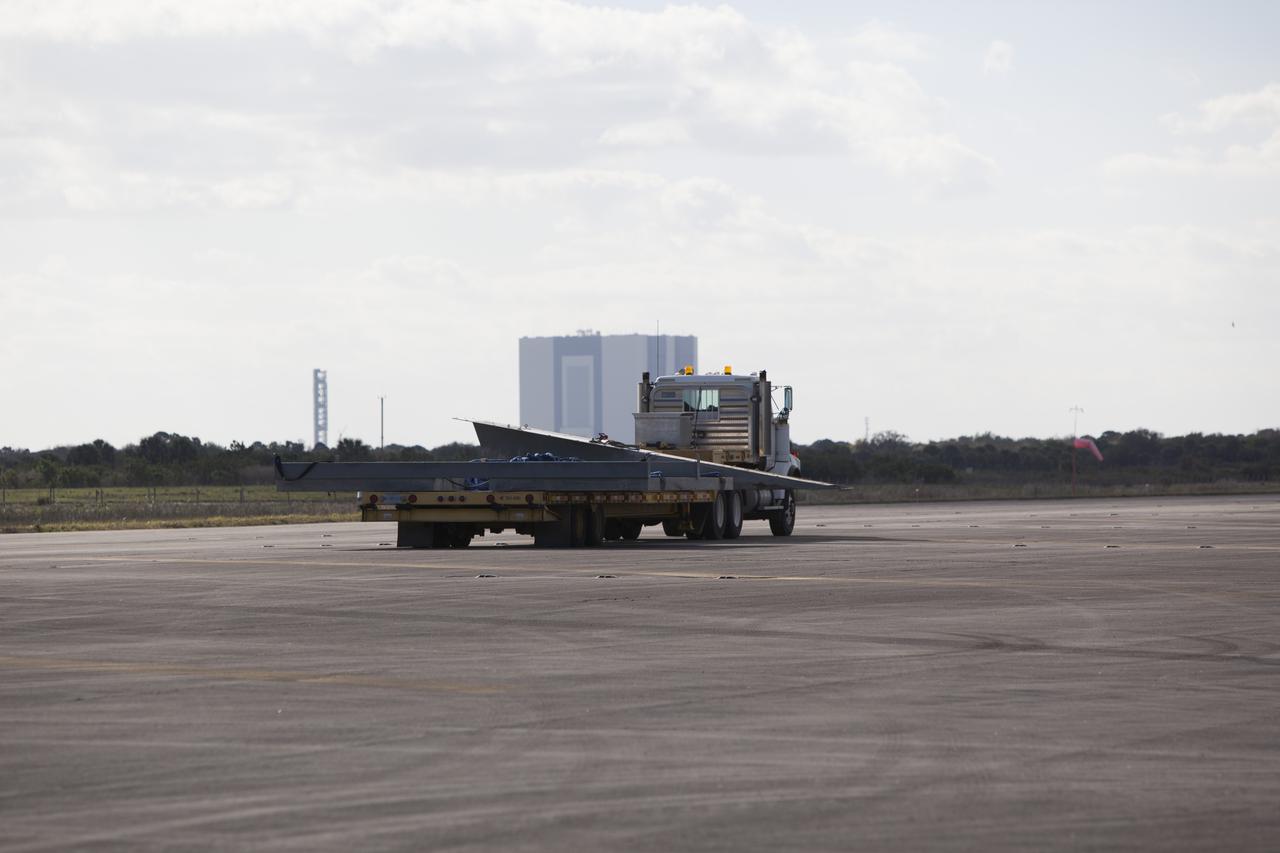 CAPE CANAVERAL, Fla. – A flatbed truck carries the launch pad for the Project Morpheus prototype lander to a new location at the north end of the Shuttle Landing Facility at NASA’s Kennedy Space Center in Florida. The launch pad is being moved to a different location to support the next phase of flight testing. Morpheus completed its seventh free flight test on March 11. The 83-second test began at 3:41 p.m. EDT with the Morpheus lander launching from the ground over a flame trench and ascending to 580 feet. Morpheus then flew its fastest downrange trek at 30 mph, travelling farther than before, 837 feet. The lander performed a 42-foot divert to emulate a hazard avoidance maneuver before descending and touching down on Landing Site 2, at the northern landing pad inside the automated landing and hazard avoidance technology ALHAT hazard field. Morpheus landed within one foot of its intended target. Project Morpheus tests NASA’s ALHAT and an engine that runs on liquid oxygen and methane, or green propellants, into a fully-operational lander that could deliver cargo to other planetary surfaces. The landing facility provides the lander with the kind of field necessary for realistic testing, complete with rocks, craters and hazards to avoid. Morpheus’ ALHAT payload allows it to navigate to clear landing sites amidst rocks, craters and other hazards during its descent. Project Morpheus is being managed under the Advanced Exploration Systems, or AES, Division in NASA’s Human Exploration and Operations Mission Directorate. The efforts in AES pioneer new approaches for rapidly developing prototype systems, demonstrating key capabilities and validating operational concepts for future human missions beyond Earth orbit. For more information on Project Morpheus, visit http://morpheuslander.jsc.nasa.gov/. Photo credit: NASA/Dimitri Gerondidakis