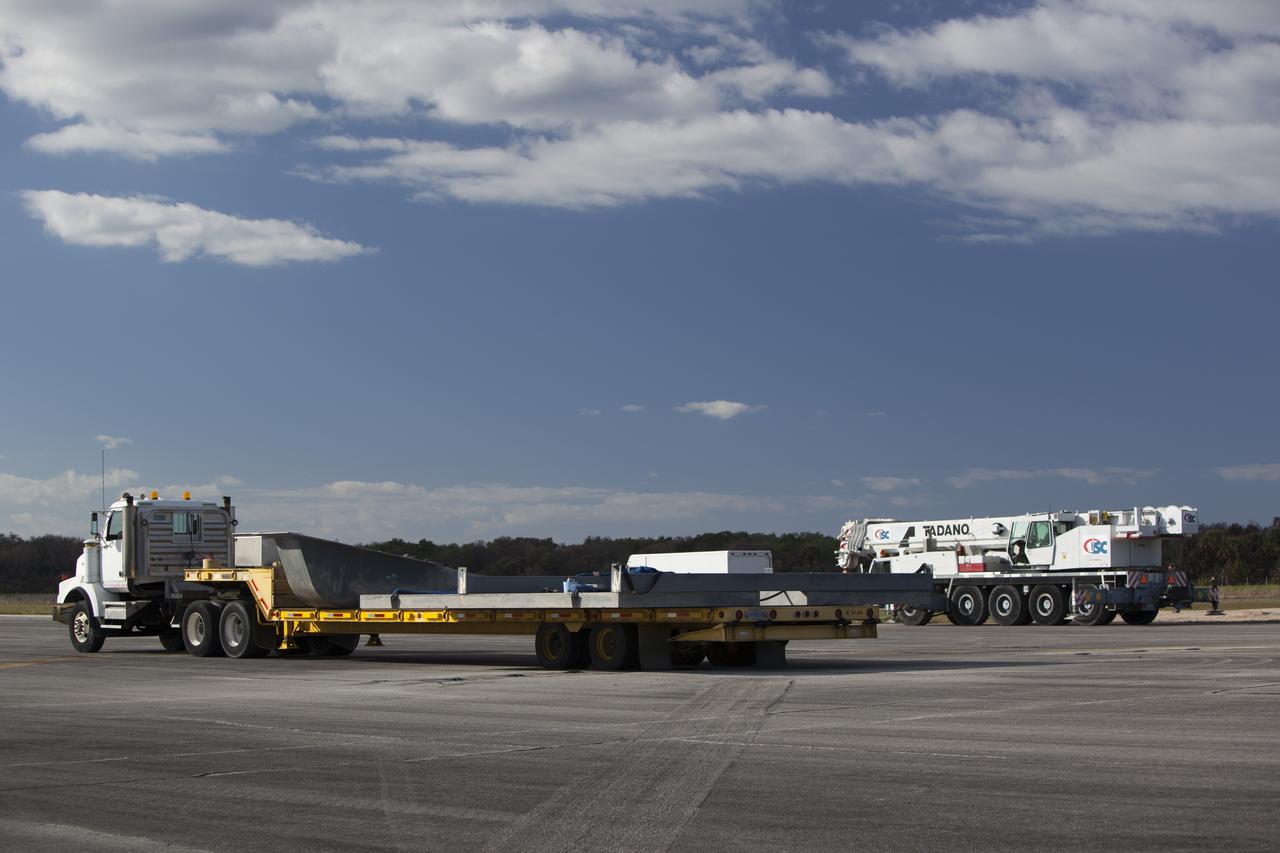CAPE CANAVERAL, Fla. – A flatbed truck carries the launch pad for the Project Morpheus prototype lander to a new location at the north end of the Shuttle Landing Facility at NASA’s Kennedy Space Center in Florida. The launch pad is being moved to a different location to support the next phase of flight testing. Morpheus completed its seventh free flight test on March 11. The 83-second test began at 3:41 p.m. EDT with the Morpheus lander launching from the ground over a flame trench and ascending to 580 feet. Morpheus then flew its fastest downrange trek at 30 mph, travelling farther than before, 837 feet. The lander performed a 42-foot divert to emulate a hazard avoidance maneuver before descending and touching down on Landing Site 2, at the northern landing pad inside the automated landing and hazard avoidance technology ALHAT hazard field. Morpheus landed within one foot of its intended target. Project Morpheus tests NASA’s ALHAT and an engine that runs on liquid oxygen and methane, or green propellants, into a fully-operational lander that could deliver cargo to other planetary surfaces. The landing facility provides the lander with the kind of field necessary for realistic testing, complete with rocks, craters and hazards to avoid. Morpheus’ ALHAT payload allows it to navigate to clear landing sites amidst rocks, craters and other hazards during its descent. Project Morpheus is being managed under the Advanced Exploration Systems, or AES, Division in NASA’s Human Exploration and Operations Mission Directorate. The efforts in AES pioneer new approaches for rapidly developing prototype systems, demonstrating key capabilities and validating operational concepts for future human missions beyond Earth orbit. For more information on Project Morpheus, visit http://morpheuslander.jsc.nasa.gov/. Photo credit: NASA/Dimitri Gerondidakis