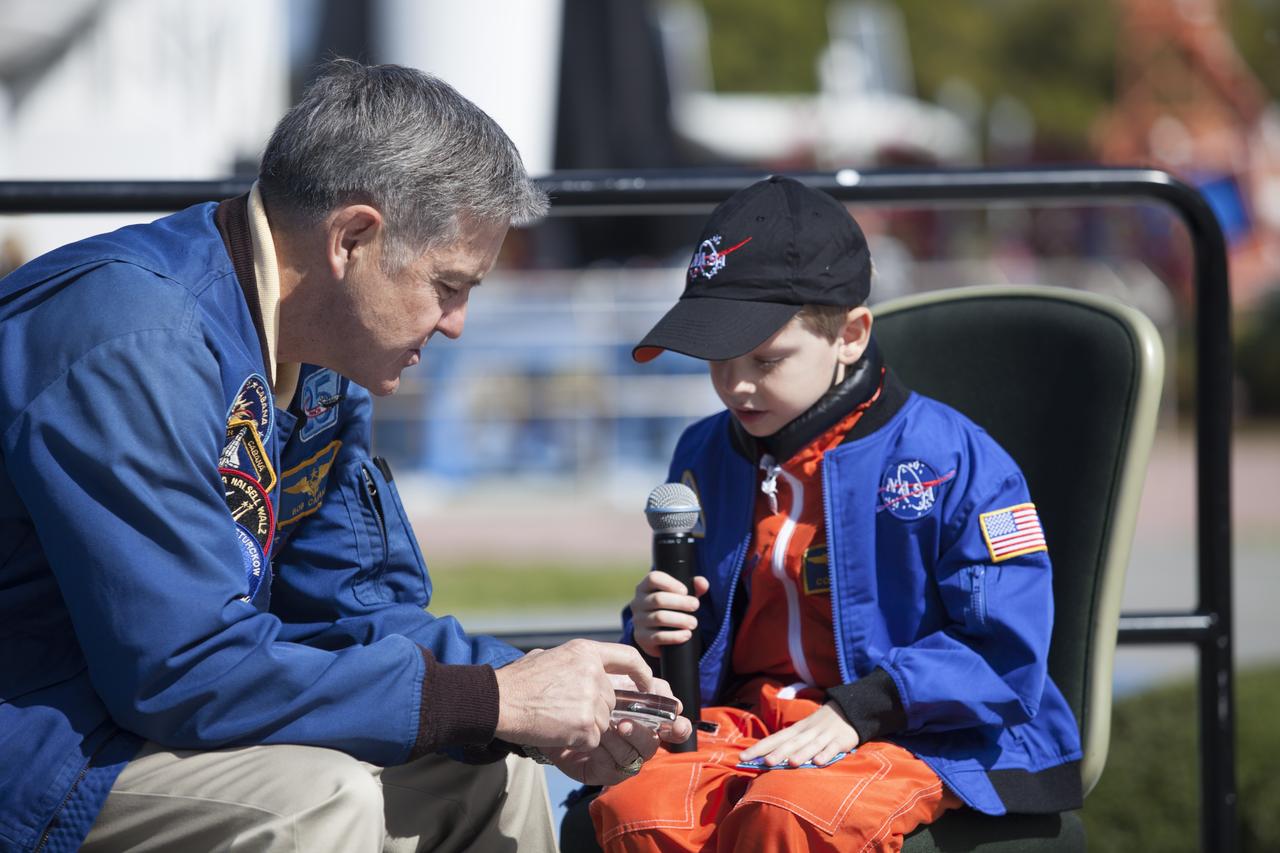 CAPE CANAVERAL, Fla. – NASA Kennedy Space Center Director and former astronaut Robert Cabana, left, presents a space-program memento to six-year-old Connor Johnson in the Kennedy Space Center Visitor Complex' Rocket Garden to inspire the youngster to continue the dream he has had since the age of three of becoming an astronaut. Connor, of Denver, Colo., gained national attention for having the "right stuff" when he launched an online petition on the White House website in December 2013 to save NASA’s funding from budget cuts. One of the mementos, a piece of space history, was a bolt used to hold the International Space Station's Unity module in place in space shuttle Endeavour's payload bay on the STS-88 mission, the first station assembly mission and Cabana's fourth and final spaceflight. Connor and his family were the guests of Delaware North Companies Parks & Resorts, the concessionaire managing the visitor complex. During his visit, Connor had the opportunity to meet with astronauts, see space vehicles and witness the Robot Rocket Rally underway in the complex' Rocket Garden over the weekend. To learn more about the educational activities available daily at the Kennedy Space Center Visitor Complex, visit http://www.kennedyspacecenter.com. Photo credit: NASA/Dan Casper