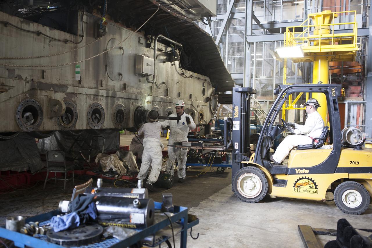 CAPE CANAVERAL, Fla. – Inside the Vehicle Assembly Building at NASA’s Kennedy Space Center in Florida, ground support technicians assist with removal of a bearing from the B truck tread of crawler-transporter 2, or CT-2, and prepare to load it on a forklift for disposal. New roller bearing assemblies will be installed.    Work continues in high bay 2 to upgrade CT-2. The modifications are designed to ensure CT-2’s ability to transport launch vehicles currently in development, such as the agency’s Space Launch System, to the launch pad. The Ground Systems Development and Operations Program office at Kennedy is overseeing the upgrades. For more than 45 years the crawler-transporters were used to transport the mobile launcher platform and the Apollo-Saturn V rockets and, later, space shuttles to Launch Pads 39A and B. For more information, visit: http://www.nasa.gov/exploration/systems/ground/crawler-transporter. Photo credit: NASA/Dimitri Gerondidakis