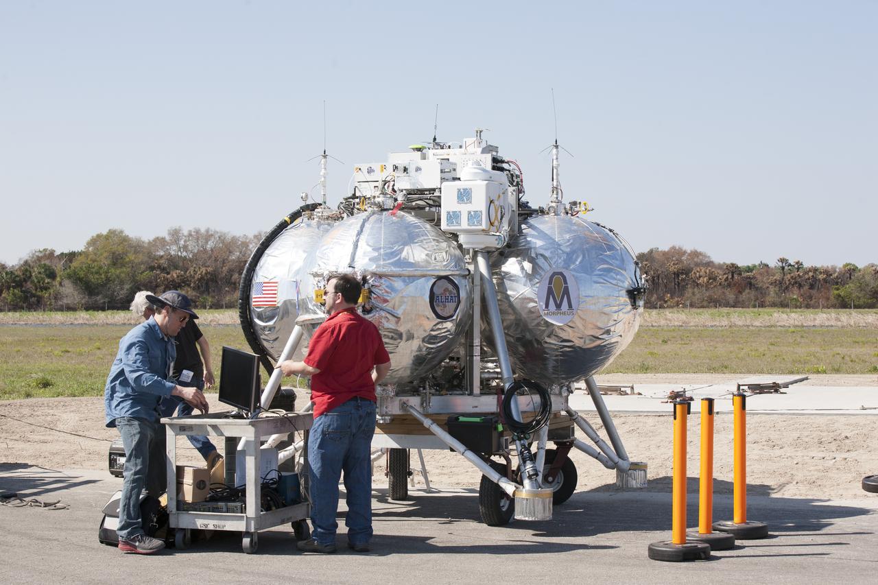 CAPE CANAVERAL, Fla. – Engineers run an automated landing and hazard avoidance technology, or ALHAT, and laser test on the Project Morpheus prototype lander at a new launch site at the north end of the Shuttle Landing Facility at NASA’s Kennedy Space Center in Florida. The launch pad was moved to a different location at the landing facility to support the next phase of flight testing. The seventh free flight test of Morpheus occurred on March 11. The 83-second test began at 3:41 p.m. EDT with the Morpheus lander launching from the ground over a flame trench and ascending to 580 feet. Morpheus then flew its fastest downrange trek at 30 mph, travelling farther than before, 837 feet. The lander performed a 42-foot divert to emulate a hazard avoidance maneuver before descending and touching down on Landing Site 2, at the northern landing pad inside the ALHAT hazard field. Morpheus landed within one foot of its intended target. Project Morpheus tests NASA’s ALHAT and an engine that runs on liquid oxygen and methane, or green propellants, into a fully-operational lander that could deliver cargo to other planetary surfaces. The landing facility provides the lander with the kind of field necessary for realistic testing, complete with rocks, craters and hazards to avoid. Morpheus’ ALHAT payload allows it to navigate to clear landing sites amidst rocks, craters and other hazards during its descent. Project Morpheus is being managed under the Advanced Exploration Systems, or AES, Division in NASA’s Human Exploration and Operations Mission Directorate. The efforts in AES pioneer new approaches for rapidly developing prototype systems, demonstrating key capabilities and validating operational concepts for future human missions beyond Earth orbit. For more information on Project Morpheus, visit http://morpheuslander.jsc.nasa.gov/. Photo credit: NASA/Kim Shiflett
