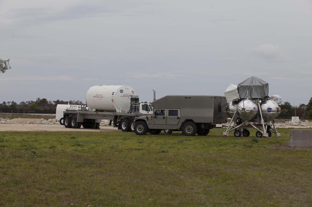 CAPE CANAVERAL, Fla. – NASA's Project Morpheus prototype lander is positioned near a new launch site at the north end of the Shuttle Landing Facility at NASA’s Kennedy Space Center in Florida for a tether test. The launch pad was moved to a different location at the landing facility to support the next phase of flight testing. Project Morpheus tests NASA’s automated landing and hazard avoidance technology, or ALHAT, and an engine that runs on liquid oxygen and methane, or green propellants, into a fully-operational lander that could deliver cargo to other planetary surfaces. The landing facility provides the lander with the kind of field necessary for realistic testing, complete with rocks, craters and hazards to avoid. Morpheus’ ALHAT payload allows it to navigate to clear landing sites amidst rocks, craters and other hazards during its descent. Project Morpheus is being managed under the Advanced Exploration Systems, or AES, Division in NASA’s Human Exploration and Operations Mission Directorate. The efforts in AES pioneer new approaches for rapidly developing prototype systems, demonstrating key capabilities and validating operational concepts for future human missions beyond Earth orbit. For more information on Project Morpheus, visit http://morpheuslander.jsc.nasa.gov/. Photo credit: NASA/Ben Smegelsky