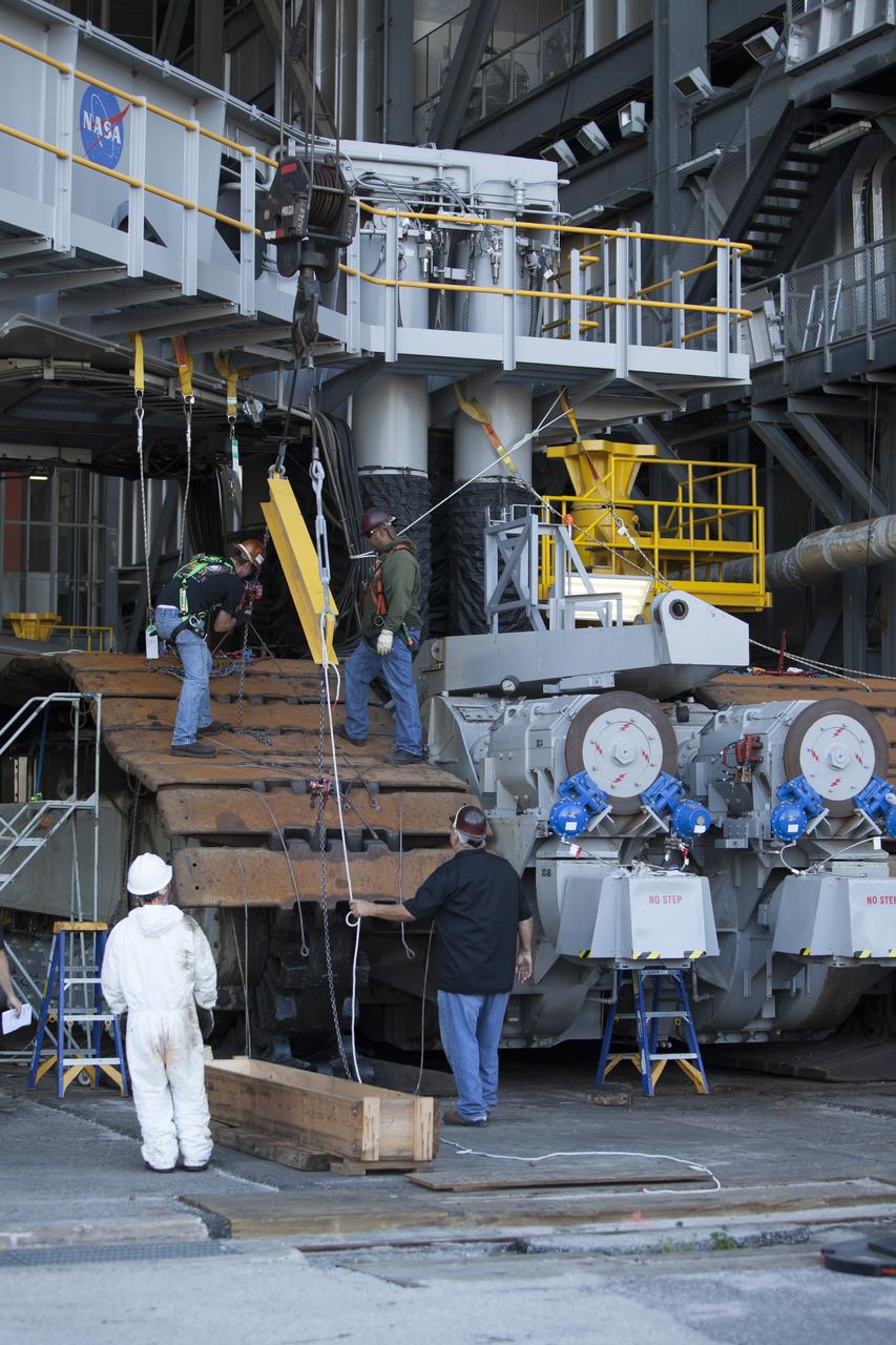 CAPE CANAVERAL, Fla. – Inside the Vehicle Assembly Building at NASA’s Kennedy Space Center in Florida, ground support technicians attach crane lines to the treads on the C truck of crawler-transporter 2, or CT-2, so they can be lifted up and away. The treads are being removed in order to gain access to remove the gear boxes. Work continues in high bay 2 to upgrade CT-2. The modifications are designed to ensure CT-2’s ability to transport launch vehicles currently in development, such as the agency’s Space Launch System, to the launch pad. The Ground Systems Development and Operations Program office at Kennedy is overseeing the upgrades. For more than 45 years the crawler-transporters were used to transport the mobile launcher platform and the Apollo-Saturn V rockets and, later, space shuttles to Launch Pads 39A and B. For more information, visit: http://www.nasa.gov/exploration/systems/ground/crawler-transporter. Photo credit: NASA/Dimitri Gerondidakis