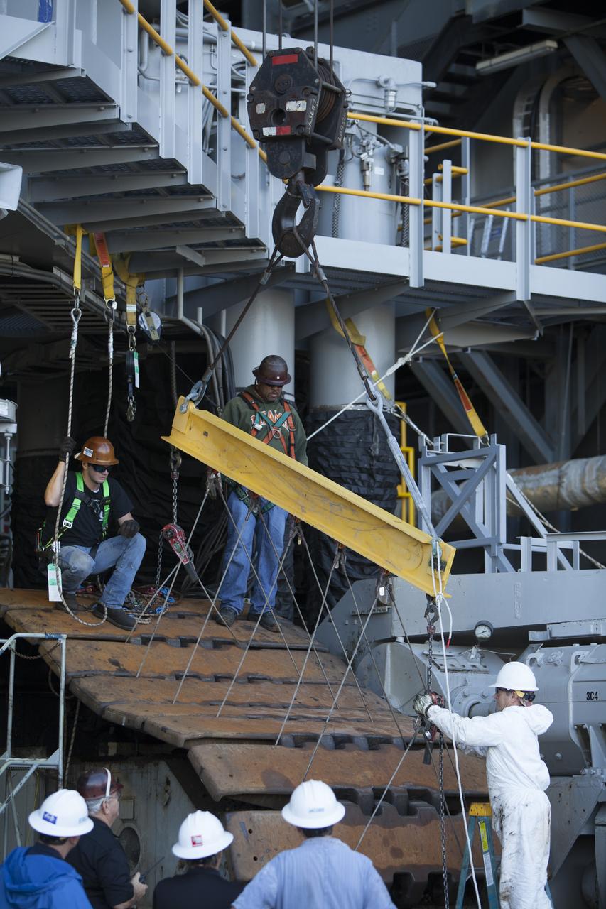 CAPE CANAVERAL, Fla. – Inside the Vehicle Assembly Building at NASA’s Kennedy Space Center in Florida, ground support technicians attach crane lines to the treads on the C truck of crawler-transporter 2, or CT-2, so they can be lifted up and away. The treads are being removed in order to gain access to remove the gear boxes. Work continues in high bay 2 to upgrade CT-2. The modifications are designed to ensure CT-2’s ability to transport launch vehicles currently in development, such as the agency’s Space Launch System, to the launch pad. The Ground Systems Development and Operations Program office at Kennedy is overseeing the upgrades. For more than 45 years the crawler-transporters were used to transport the mobile launcher platform and the Apollo-Saturn V rockets and, later, space shuttles to Launch Pads 39A and B. For more information, visit: http://www.nasa.gov/exploration/systems/ground/crawler-transporter. Photo credit: NASA/Dimitri Gerondidakis