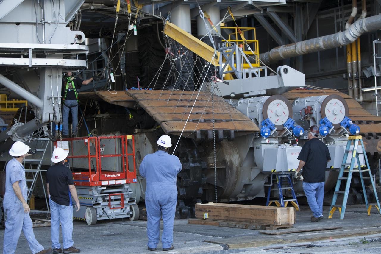 CAPE CANAVERAL, Fla. – Inside the Vehicle Assembly Building at NASA’s Kennedy Space Center in Florida, ground support technicians have attached crane lines to a portion of the treads on the C truck of crawler-transporter 2, or CT-2, so they can be lifted up and away. The treads are being removed in order to gain access to remove the gear boxes. Work continues in high bay 2 to upgrade CT-2. The modifications are designed to ensure CT-2’s ability to transport launch vehicles currently in development, such as the agency’s Space Launch System, to the launch pad. The Ground Systems Development and Operations Program office at Kennedy is overseeing the upgrades. For more than 45 years the crawler-transporters were used to transport the mobile launcher platform and the Apollo-Saturn V rockets and, later, space shuttles to Launch Pads 39A and B. For more information, visit: http://www.nasa.gov/exploration/systems/ground/crawler-transporter. Photo credit: NASA/Dimitri Gerondidakis