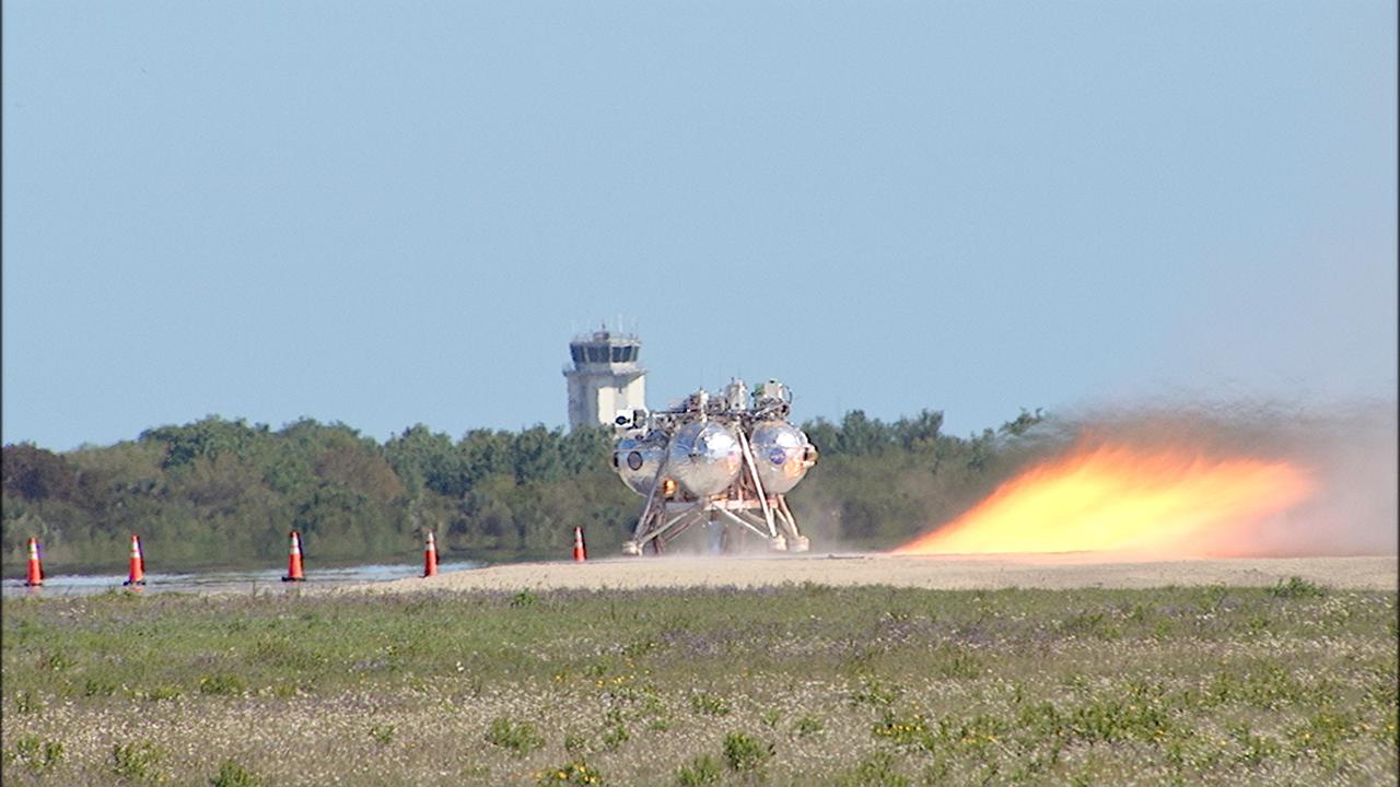 CAPE CANAVERAL, Fla. – A free flight test of NASA's Project Morpheus prototype lander begins at the new launch site at the north end of the Shuttle Landing Facility at NASA’s Kennedy Space Center in Florida. The 96-second test began at 4:21 p.m. EDT with the Morpheus lander launching from the ground over the flame trench and ascending more than 800 feet at a peak speed of 36 mph. The vehicle with its recently installed autonomous landing and hazard avoidance technology, or ALHAT, sensors surveyed the hazard field to determine safe landing sites. Morpheus then flew forward and downward covering 1,300 feet while performing a 78-foot divert to simulate a hazard avoidance maneuver. The lander descended and landed on a dedicated pad inside the ALHAT field. Project Morpheus tests NASA’s ALHAT, and an engine that runs on liquid oxygen and methane, or green propellants, into a fully-operational lander that could deliver cargo to other planetary surfaces. The landing facility provides the lander with the kind of field necessary for realistic testing, complete with rocks, craters and hazards to avoid. Morpheus’ ALHAT payload allows it to navigate to clear landing sites amidst rocks, craters and other hazards during its descent. Project Morpheus is being managed under the Advanced Exploration Systems, or AES, Division in NASA’s Human Exploration and Operations Mission Directorate. The efforts in AES pioneer new approaches for rapidly developing prototype systems, demonstrating key capabilities and validating operational concepts for future human missions beyond Earth orbit. For more information on Project Morpheus, visit http://morpheuslander.jsc.nasa.gov/. Photo credit: NASA/Frankie Martin