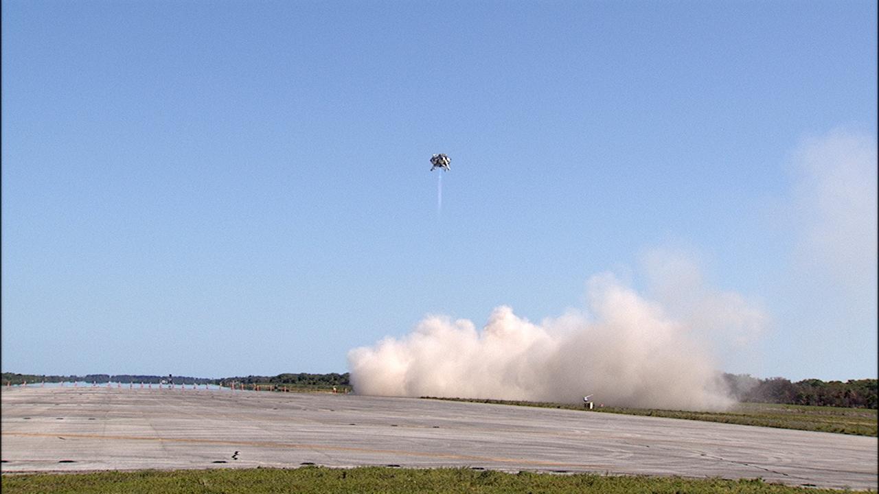 CAPE CANAVERAL, Fla. – NASA's Project Morpheus prototype lander soars high during a free flight test at the north end of the Shuttle Landing Facility at NASA's Kennedy Space Center in Florida. The 96-second test began at 4:21 p.m. EDT with the Morpheus lander launching from the ground over the flame trench at a new launch site and ascending more than 800 feet at a peak speed of 36 mph. The vehicle with its recently installed autonomous landing and hazard avoidance technology, or ALHAT, sensors surveyed the hazard field to determine safe landing sites. Morpheus then flew forward and downward covering 1,300 feet while performing a 78-foot divert to simulate a hazard avoidance maneuver. The lander descended and landed on a dedicated pad inside the ALHAT field. Project Morpheus tests NASA’s ALHAT, and an engine that runs on liquid oxygen and methane, or green propellants, into a fully-operational lander that could deliver cargo to other planetary surfaces.    The landing facility provides the lander with the kind of field necessary for realistic testing, complete with rocks, craters and hazards to avoid. Morpheus’ ALHAT payload allows it to navigate to clear landing sites amidst rocks, craters and other hazards during its descent. Project Morpheus is being managed under the Advanced Exploration Systems, or AES, Division in NASA’s Human Exploration and Operations Mission Directorate. The efforts in AES pioneer new approaches for rapidly developing prototype systems, demonstrating key capabilities and validating operational concepts for future human missions beyond Earth orbit. For more information on Project Morpheus, visit http://morpheuslander.jsc.nasa.gov/.  Photo credit: NASA/Frankie Martin