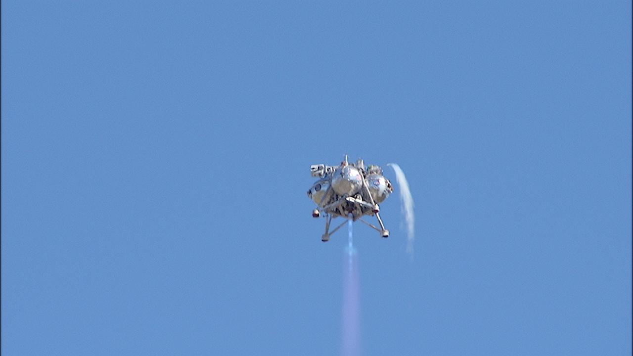 CAPE CANAVERAL, Fla. – NASA's Project Morpheus prototype lander soars high during a free flight test at the north end of the Shuttle Landing Facility at NASA's Kennedy Space Center in Florida. The 96-second test began at 4:21 p.m. EDT with the Morpheus lander launching from the ground over the flame trench at a new launch site and ascending more than 800 feet at a peak speed of 36 mph. The vehicle with its recently installed autonomous landing and hazard avoidance technology, or ALHAT, sensors surveyed the hazard field to determine safe landing sites. Morpheus then flew forward and downward covering 1,300 feet while performing a 78-foot divert to simulate a hazard avoidance maneuver. The lander descended and landed on a dedicated pad inside the ALHAT field. Project Morpheus tests NASA’s ALHAT, and an engine that runs on liquid oxygen and methane, or green propellants, into a fully-operational lander that could deliver cargo to other planetary surfaces.    The landing facility provides the lander with the kind of field necessary for realistic testing, complete with rocks, craters and hazards to avoid. Morpheus’ ALHAT payload allows it to navigate to clear landing sites amidst rocks, craters and other hazards during its descent. Project Morpheus is being managed under the Advanced Exploration Systems, or AES, Division in NASA’s Human Exploration and Operations Mission Directorate. The efforts in AES pioneer new approaches for rapidly developing prototype systems, demonstrating key capabilities and validating operational concepts for future human missions beyond Earth orbit. For more information on Project Morpheus, visit http://morpheuslander.jsc.nasa.gov/.  Photo credit: NASA/Frankie Martin