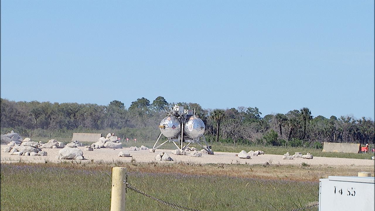 CAPE CANAVERAL, Fla. – NASA's Project Morpheus prototype lander lands inside the autonomous landing and hazard avoidance technology, or ALHAT, hazard field after a free flight test at the north end of the Shuttle Landing Facility at NASA's Kennedy Space Center in Florida. The 96-second test began at 4:21 p.m. EDT with the Morpheus lander launching from the ground over the flame trench at a new launch site and ascending more than 800 feet at a peak speed of 36 mph. The vehicle with its recently installed autonomous landing and hazard avoidance technology, or ALHAT, sensors surveyed the hazard field to determine safe landing sites. Morpheus then flew forward and downward covering 1,300 feet while performing a 78-foot divert to simulate a hazard avoidance maneuver. The lander descended and landed on a dedicated pad inside the ALHAT field. Project Morpheus tests NASA’s ALHAT, and an engine that runs on liquid oxygen and methane, or green propellants, into a fully-operational lander that could deliver cargo to other planetary surfaces.    The landing facility provides the lander with the kind of field necessary for realistic testing, complete with rocks, craters and hazards to avoid. Morpheus’ ALHAT payload allows it to navigate to clear landing sites amidst rocks, craters and other hazards during its descent. Project Morpheus is being managed under the Advanced Exploration Systems, or AES, Division in NASA’s Human Exploration and Operations Mission Directorate. The efforts in AES pioneer new approaches for rapidly developing prototype systems, demonstrating key capabilities and validating operational concepts for future human missions beyond Earth orbit. For more information on Project Morpheus, visit http://morpheuslander.jsc.nasa.gov/.  Photo credit: NASA/Frankie Martin