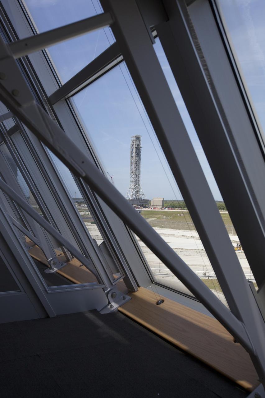CAPE CANAVERAL, Fla. – The Mobile Launcher is visible through a window inside Firing Room 4 in the Launch Control Center at NASA's Kennedy Space Center in Florida. The Ground Systems Development and Operations Program is overseeing efforts to create a new multi-user firing room in Firing Room 4. The main floor consoles, cabling and wires below the floor and ceiling tiles above have been removed. Sub-flooring has been installed and the room is marked off to create four separate rooms on the main floor.     The design of Firing Room 4 will incorporate five control room areas that are flexible to meet current and future NASA and commercial user requirements. The equipment and most of the consoles from Firing Room 4 were moved to Firing Room 2 for possible future reuse. Photo credit: NASA/Ben Smegelsky