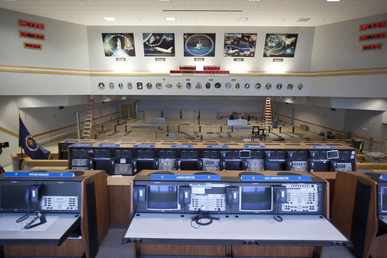 CAPE CANAVERAL, Fla. – Three rows of upper level management consoles are all that remain in Firing Room 4 in the Launch Control Center at NASA’s Kennedy Space Center in Florida. The Ground Systems Development and Operations Program is overseeing efforts to create a new firing room based on a multi-user concept that will support NASA and commercial launch needs. The main floor consoles, cabling and wires below the floor and ceiling tiles above have been removed. Sub flooring has been installed and the room is marked off to create four separate rooms on the main floor. In view along the soffit are space shuttle launch plaques for 21 missions launched from Firing Room 4. The design of Firing Room 4 will incorporate five control room areas that are flexible to meet current and future NASA and commercial user requirements. The equipment and most of the consoles from Firing Room 4 were moved to Firing Room 2 for possible future reuse. Photo credit: NASA/Ben Smegelsky