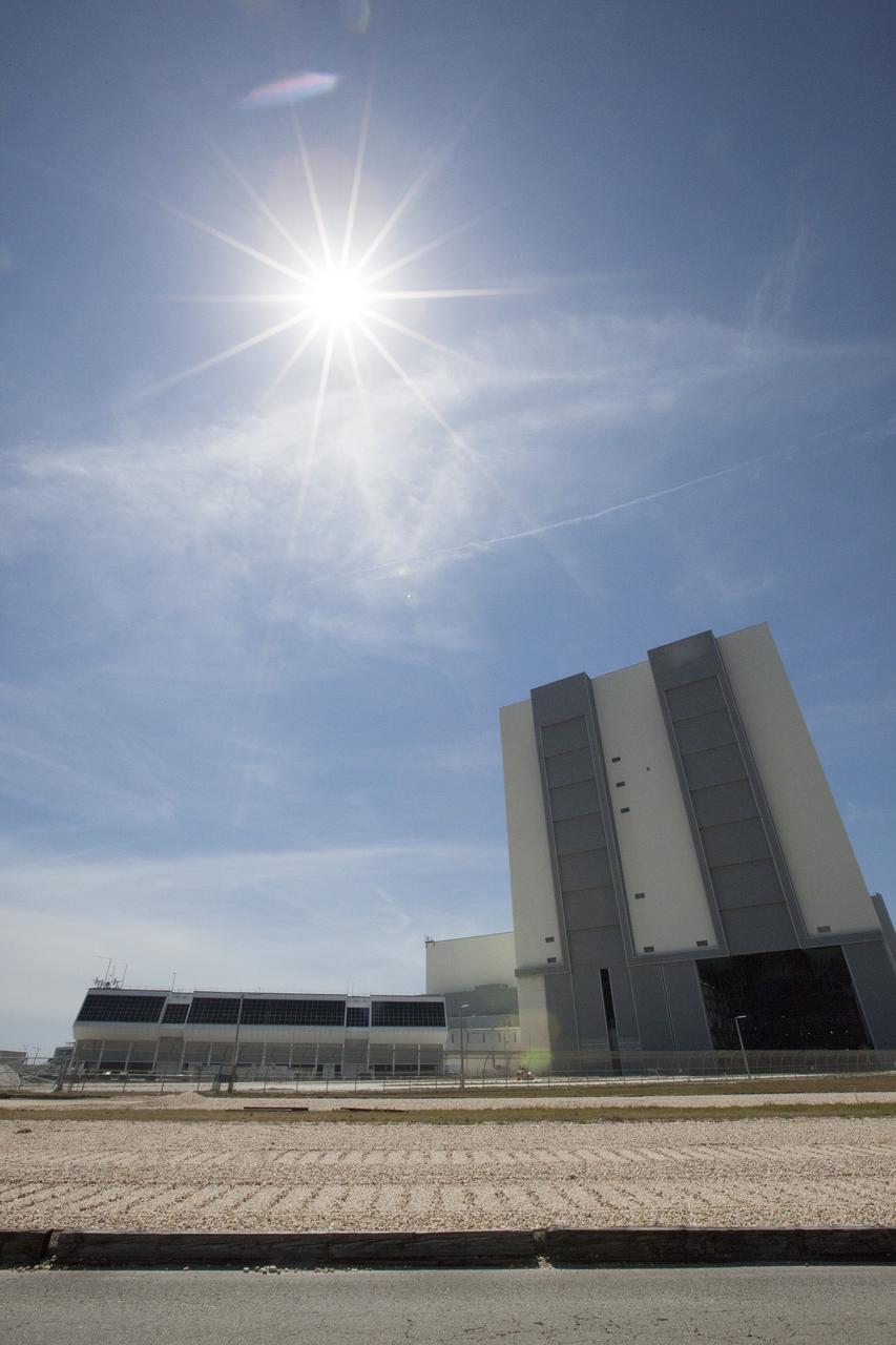 CAPE CANAVERAL, Fla. – A portion of the crawlerway, the Vehicle Assembly Building and the Launch Control Center are illuminated by a bright sun in this view looking west at NASA's Kennedy Space Center in Florida. Inside Firing Room 4 in the Launch Control Center, the Ground Systems Development and Operations Program is overseeing efforts to create a new firing room based on a multi-user concept.     The design of Firing Room 4 will incorporate five control room areas that are flexible to meet current and future NASA and commercial user requirements. The equipment and most of the consoles from Firing Room 4 were moved to Firing Room 2 for possible future reuse. Photo credit: NASA/Ben Smegelsky