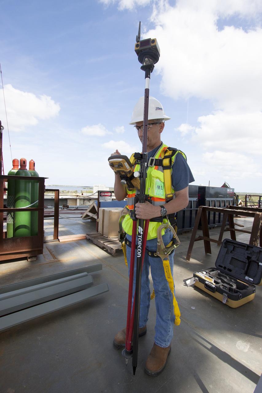 CAPE CANAVERAL, Fla. – Modifications continue on the Mobile Launcher, or ML, at the Mobile Launcher Park Site at NASA’s Kennedy Space Center in Florida. A construction worker uses a measuring device on the surface of the ML.    In 2013, the agency awarded a contract to J.P. Donovan Construction Inc. of Rockledge, Fla., to modify the ML, which is one of the key elements of ground support equipment that is being upgraded by the Ground Systems Development and Operations Program office at Kennedy. The ML will carry the SLS rocket and Orion spacecraft to Launch Pad 39B for its first mission, Exploration Mission 1, in 2017. Photo credit: NASA/Cory Huston