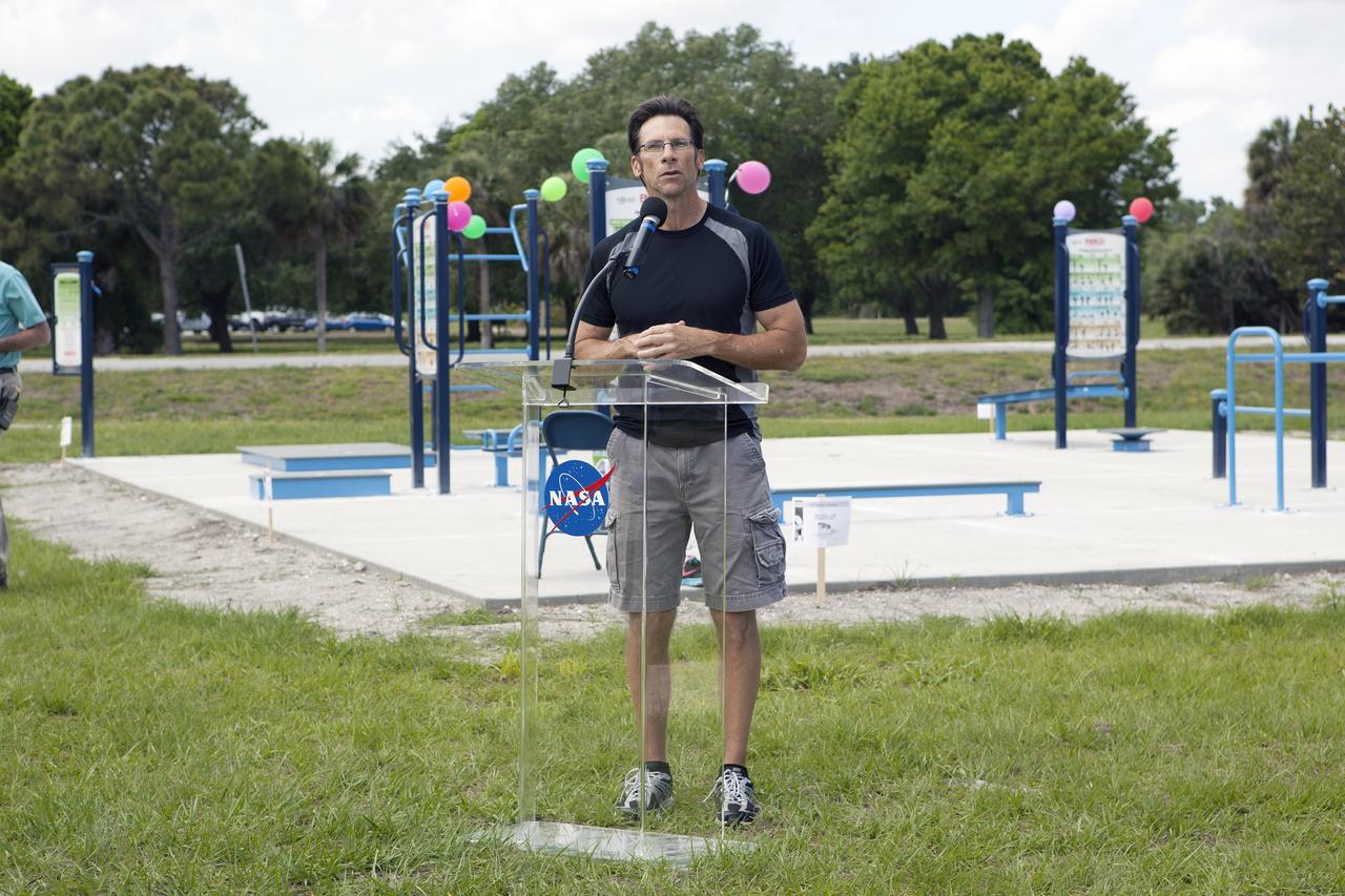 CAPE CANAVERAL, Fla. - Dressed for a little exercise, Deputy Program Manager of Launch Services Chuck Dovale addresses the employees who have turned out during their lunchtime for a ribbon-cutting ceremony opening the new fitness trail next to the Space Station Processing Facility at NASA's Kennedy Space Center in Florida. The one-mile-long track will provide employees with a safe place off Kennedy's roadways to walk or run. The more than 6 tons of green waste removed to create the trail's footprint will be mulched and used for cover at Kennedy's landfill. Approximately 1,594 tons of crawler fines -- ground-up crawler rock removed from the crawlerway in the Launch Complex 39 area -- was used for the foundation of the trail. Fitness equipment has been ordered and will be installed on a concrete slab at the trail's west end. After the equipment has been installed, the slab will be coated to provide a rubberized exercise pad. At Kennedy Space Center, the health and safety of every employee is paramount. To learn more about Kennedy, visit http://www.nasa.gov/kennedy. Photo credit: NASA/Frankie Martin