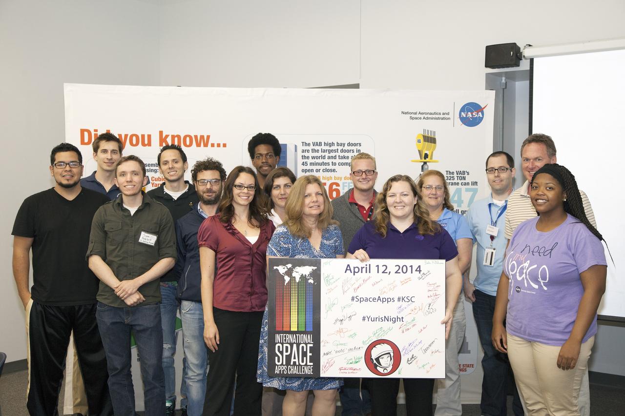 CAPE CANAVERAL, Fla. - Members of the winning Astronaut Resource Managing System and SpaceWear teams in the International Space Apps Challenge pose for a group portrait with the NASA volunteers, judges and event organizers. From left are Alejandro Velasco, NASA's Justin Treptow, Sam Neblett, Roberto Ricci, James Brucato, NASA's Suzanne Plantec, Keith Hargett, NASA's Cynthia Duffaut, NASA's Launa Maier, event organizer James Wood, event organizer lead Caley Burke, NASA's Lisa Singleton, event organizer David Miranda, NASA Ground Systems Development and Operation Program Manager Michael Bolger and NASA intern Brandi Burse.      Kennedy Space Center hosted one of the over 90 locations around the world where participants congregated for the attempt to design innovative solutions for global challenges over a 48-hour period. This year's development marathon focused on five NASA mission areas: Asteroids, Earth Watch, Human Spaceflight, Robotics, and Technology in Space. Three of this year’s challenges were developed by KSC employees: Space Wearables: Fashion Designer to Astronauts, Growing Food for a Martian Table, and Asteroid Prospector. The winners selected in 2014 at Kennedy were Astronaut Resource Managing System, or ARMS, for Best Use of Data and SpaceWear for Best Use of Hardware. ARMS also took the People's Choice Award. For more information, visit https://2014.spaceappschallenge.org.  Photo credit: NASA/Daniel Casper