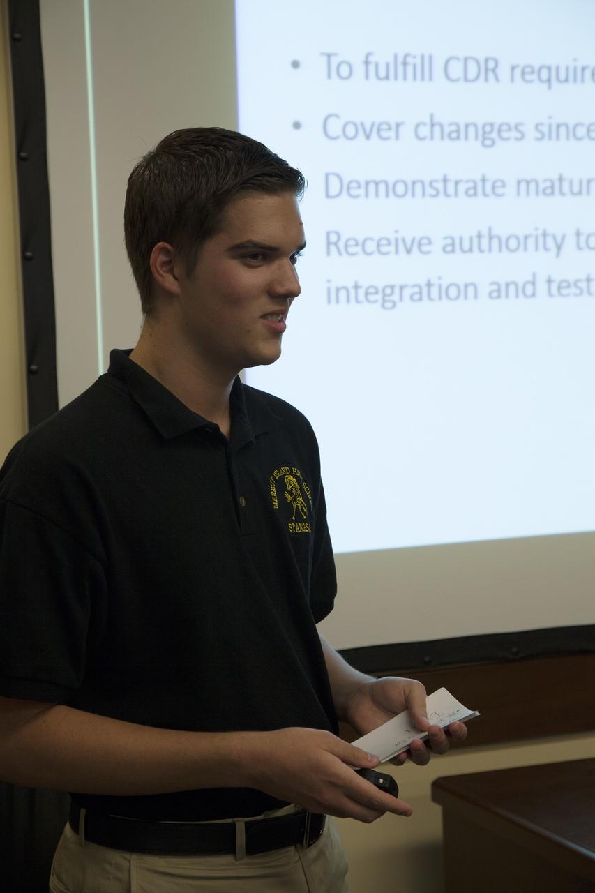 CAPE CANAVERAL, Fla. – A student representing a team from Merritt Island High School presents their StangSat concepts to NASA engineers at a Critical Design Review in the Operations and Checkout Building at NASA's Kennedy Space Center in Florida.      StangSat is one of many CubeSats under development in a class of research spacecraft called nanosatellites. The cube-shaped satellites measure about 4 inches on each side, have a volume of about 1 quart and weigh less than 3 pounds. To date, 27 CubeSats have launched through the initiative as part of the agency's Launch Services Program's Educational Launch of Nanosatellite Program. This year, four separate launches will carry 17 CubeSats. To learn more about the CubeSat Launch Initiative, visit http://go.nasa.gov/CubeSat_initiative.  Photo credit: NASA/Ben Smegelsky