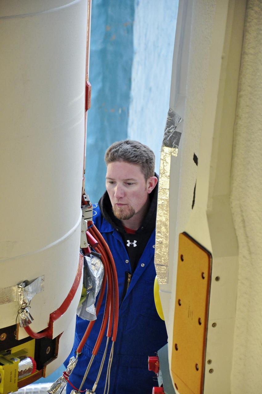 VANDENBERG AIR FORCE BASE, Calif. – A worker prepares to attach a solid rocket motor, or SRM, for NASA's Orbiting Carbon Observatory-2 mission, or OCO-2, to the Delta II first stage in the mobile service tower at Space Launch Complex 2 on Vandenberg Air Force Base in California. Operations are underway to attach the rocket's three SRMs, known as graphite epoxy motors, to its first stage.      OCO-2 is scheduled to launch into a polar Earth orbit aboard a United Launch Alliance Delta II 7320-10C rocket in July. Once in orbit, OCO-2 will collect precise global measurements of carbon dioxide in the Earth's atmosphere and provide scientists with a better idea of the chemical compound's impacts on climate change. Scientists will analyze this data to improve our understanding of the natural processes and human activities that regulate the abundance and distribution of this important atmospheric gas. To learn more about OCO-2, visit http://oco.jpl.nasa.gov.  Photo credit: NASA/Randy Beaudoin