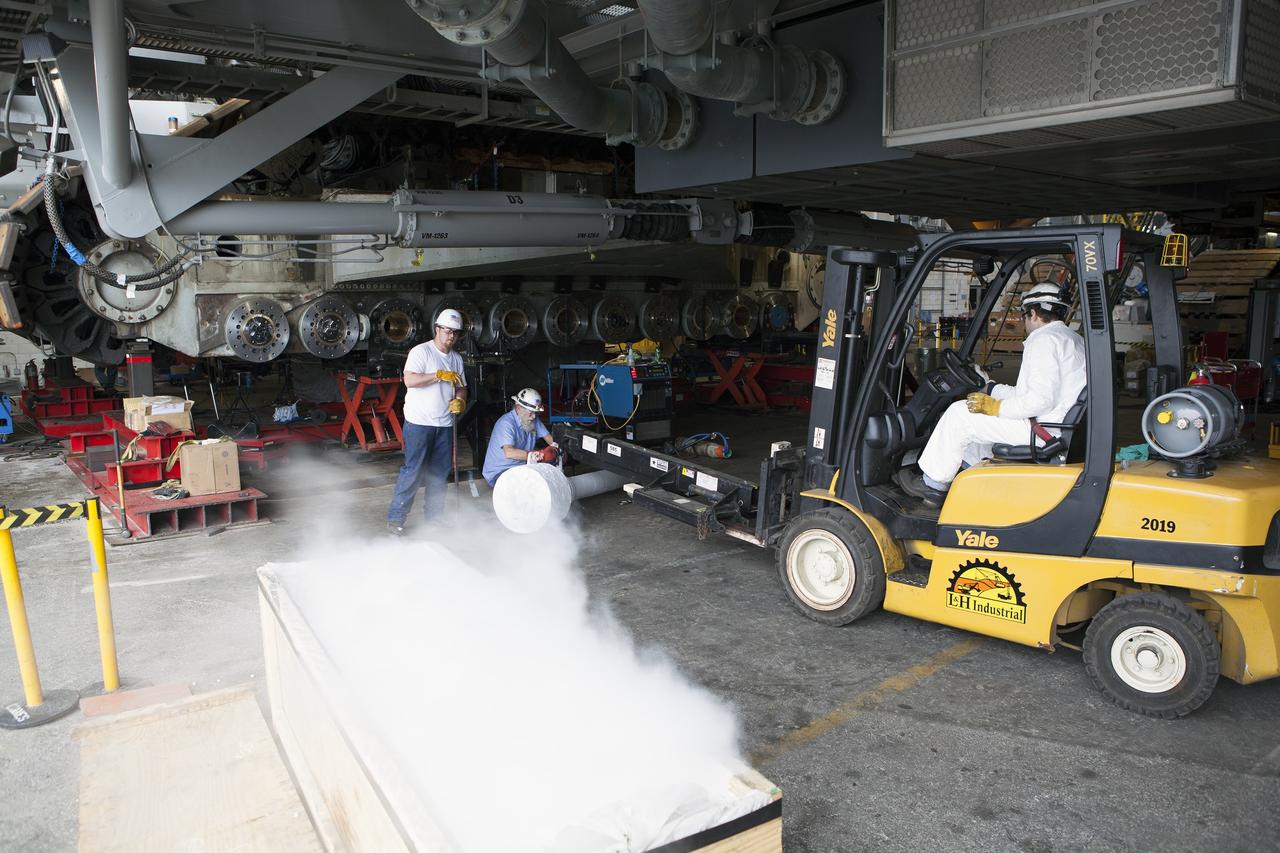 CAPE CANAVERAL, Fla. - Inside the Vehicle Assembly Building at NASA’s Kennedy Space Center in Florida, ground support technicians attach a roller bearing shaft to a forklift. The bearing is being prepared for insertion in the C truck of crawler-transporter 2, or CT-2. A section of the treads on the C truck were removed to allow access to the bearings.    Work continues in high bay 2 to upgrade CT-2. The modifications are designed to ensure CT-2’s ability to transport launch vehicles currently in development, such as the agency’s Space Launch System, to the launch pad. The Ground Systems Development and Operations Program office at Kennedy is overseeing the upgrades. For more than 45 years the crawler-transporters were used to transport the mobile launcher platform and the Apollo-Saturn V rockets and, later, space shuttles to Launch Pads 39A and B. For more information, visit: http://www.nasa.gov/exploration/systems/ground/crawler-transporter. Photo credit: NASA/Dimitri Gerondidakis