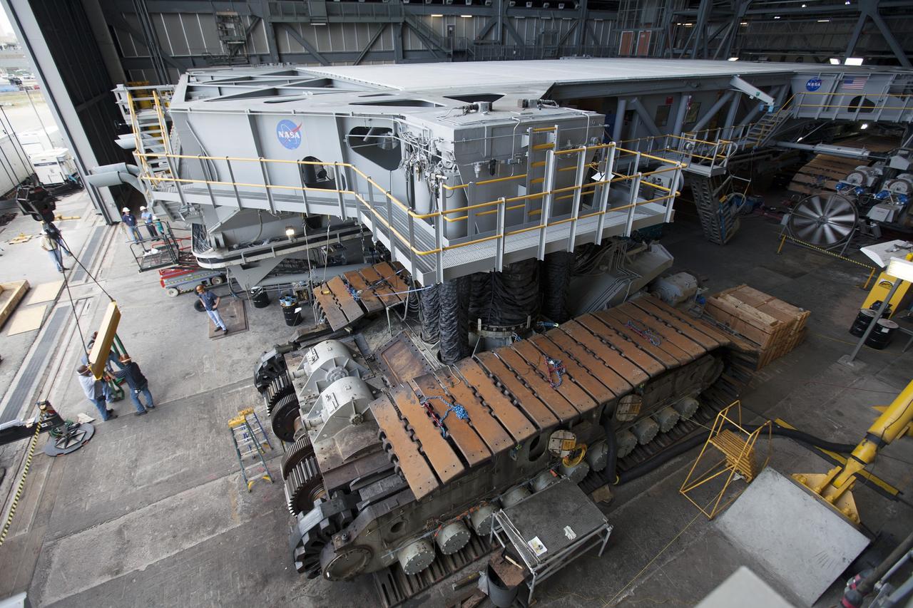 CAPE CANAVERAL, Fla. - Inside the Vehicle Assembly Building at NASA’s Kennedy Space Center in Florida, ground support technicians prepare for removal of the outboard and inboard sprocket shaft assemblies on the C truck of crawler-transporter 2, or CT-2. A section of the treads on the C truck were removed to allow access to the sprocket assemblies.    Work continues in high bay 2 to upgrade CT-2. The modifications are designed to ensure CT-2’s ability to transport launch vehicles currently in development, such as the agency’s Space Launch System, to the launch pad. The Ground Systems Development and Operations Program office at Kennedy is overseeing the upgrades. For more than 45 years the crawler-transporters were used to transport the mobile launcher platform and the Apollo-Saturn V rockets and, later, space shuttles to Launch Pads 39A and B. For more information, visit: http://www.nasa.gov/exploration/systems/ground/crawler-transporter. Photo credit: NASA/Dimitri Gerondidakis