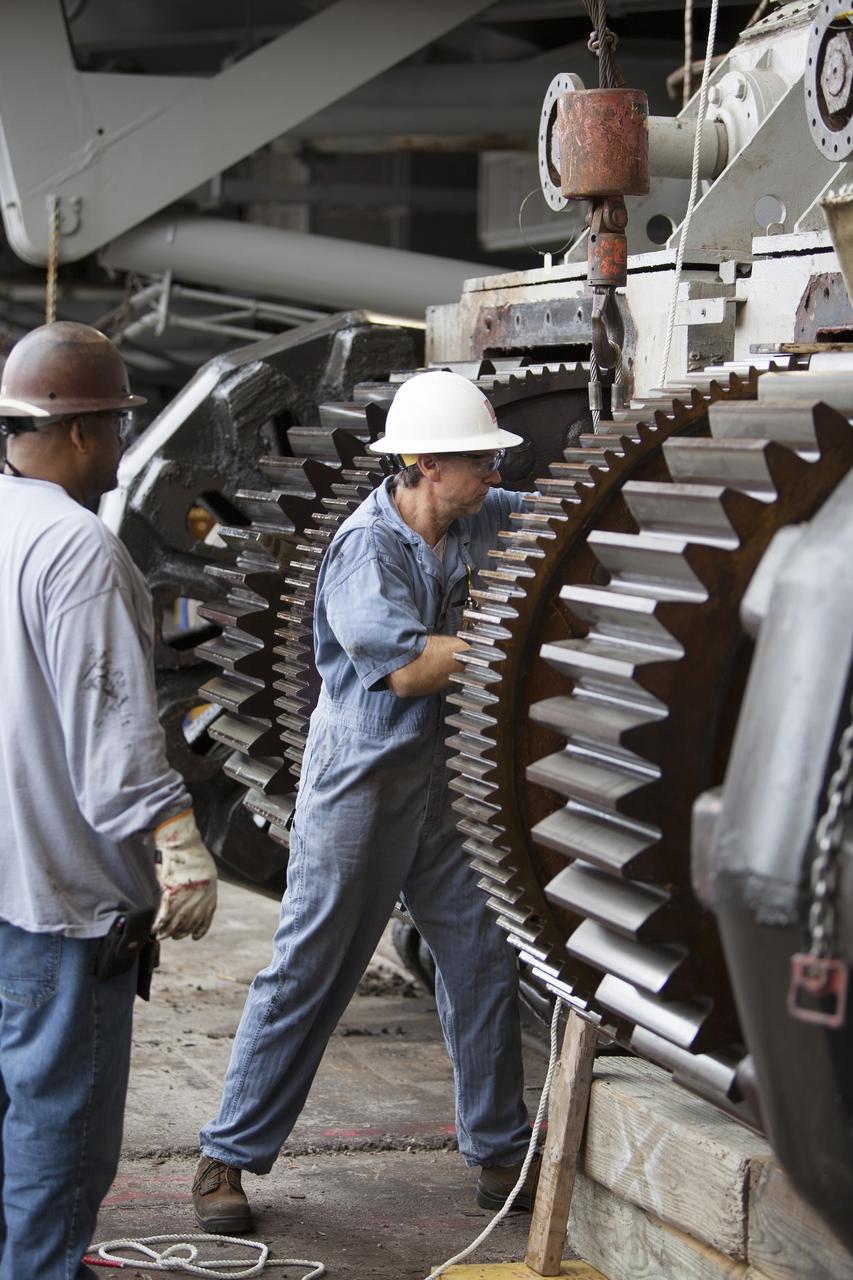 CAPE CANAVERAL, Fla. - Inside the Vehicle Assembly Building at NASA’s Kennedy Space Center in Florida, ground support technicians prepare one of the sprocket shaft assemblies on the C truck of crawler-transporter 2, or CT-2 for removal. The sprocket assemblies will be placed into shipping cradles on pallets and positioned on a flatbed trailer. They will be sent to a vendor for inspections and refurbishment.     Work continues in high bay 2 to upgrade CT-2. The modifications are designed to ensure CT-2’s ability to transport launch vehicles currently in development, such as the agency’s Space Launch System, to the launch pad. The Ground Systems Development and Operations Program office at Kennedy is overseeing the upgrades. For more than 45 years the crawler-transporters were used to transport the mobile launcher platform and the Apollo-Saturn V rockets and, later, space shuttles to Launch Pads 39A and B. For more information, visit: http://www.nasa.gov/exploration/systems/ground/crawler-transporter. Photo credit: NASA/Dimitri Gerondidakis