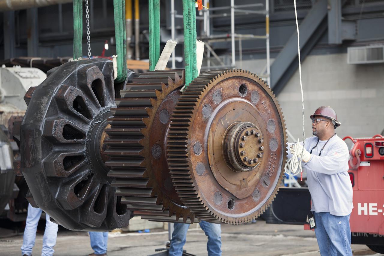 CAPE CANAVERAL, Fla. - Inside the Vehicle Assembly Building at NASA’s Kennedy Space Center in Florida, ground support technicians assist as an overhead crane lifts one of the sprocket shaft assemblies away from the C truck of crawler-transporter 2, or CT-2. The sprocket assemblies will be placed into shipping cradles on pallets and positioned on a flatbed trailer. They will be sent to a vendor for inspections and refurbishment.    Work continues in high bay 2 to upgrade CT-2. The modifications are designed to ensure CT-2’s ability to transport launch vehicles currently in development, such as the agency’s Space Launch System, to the launch pad. The Ground Systems Development and Operations Program office at Kennedy is overseeing the upgrades. For more than 45 years the crawler-transporters were used to transport the mobile launcher platform and the Apollo-Saturn V rockets and, later, space shuttles to Launch Pads 39A and B. For more information, visit: http://www.nasa.gov/exploration/systems/ground/crawler-transporter. Photo credit: NASA/Dimitri Gerondidakis