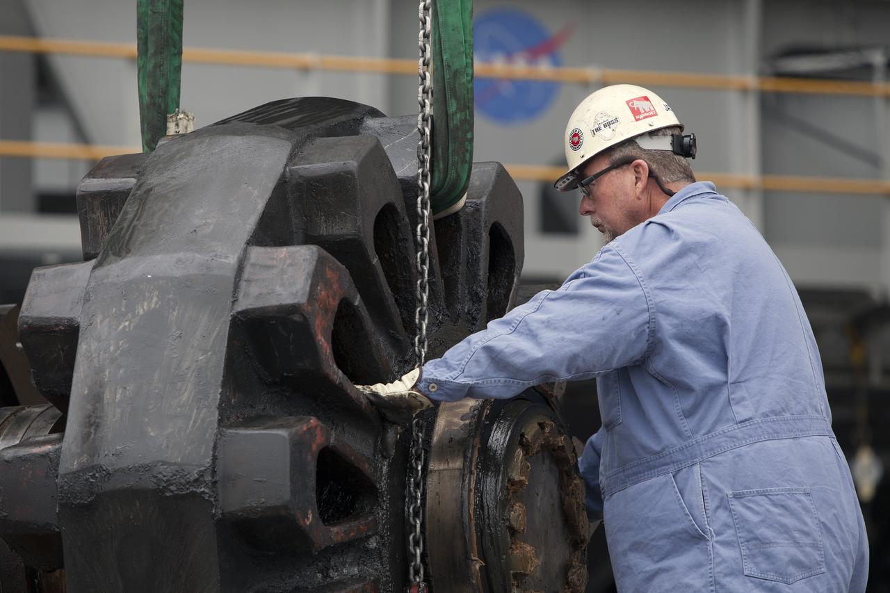 CAPE CANAVERAL, Fla. - Inside the Vehicle Assembly Building at NASA’s Kennedy Space Center in Florida, a ground support technician assists as an overhead crane lifts one of the sprocket shaft assemblies away from the C truck of crawler-transporter 2, or CT-2. The sprocket assemblies will be placed into shipping cradles on pallets and positioned on a flatbed trailer. They will be sent to a vendor for inspections and refurbishment.     Work continues in high bay 2 to upgrade CT-2. The modifications are designed to ensure CT-2’s ability to transport launch vehicles currently in development, such as the agency’s Space Launch System, to the launch pad. The Ground Systems Development and Operations Program office at Kennedy is overseeing the upgrades. For more than 45 years the crawler-transporters were used to transport the mobile launcher platform and the Apollo-Saturn V rockets and, later, space shuttles to Launch Pads 39A and B. For more information, visit: http://www.nasa.gov/exploration/systems/ground/crawler-transporter. Photo credit: NASA/Dimitri Gerondidakis