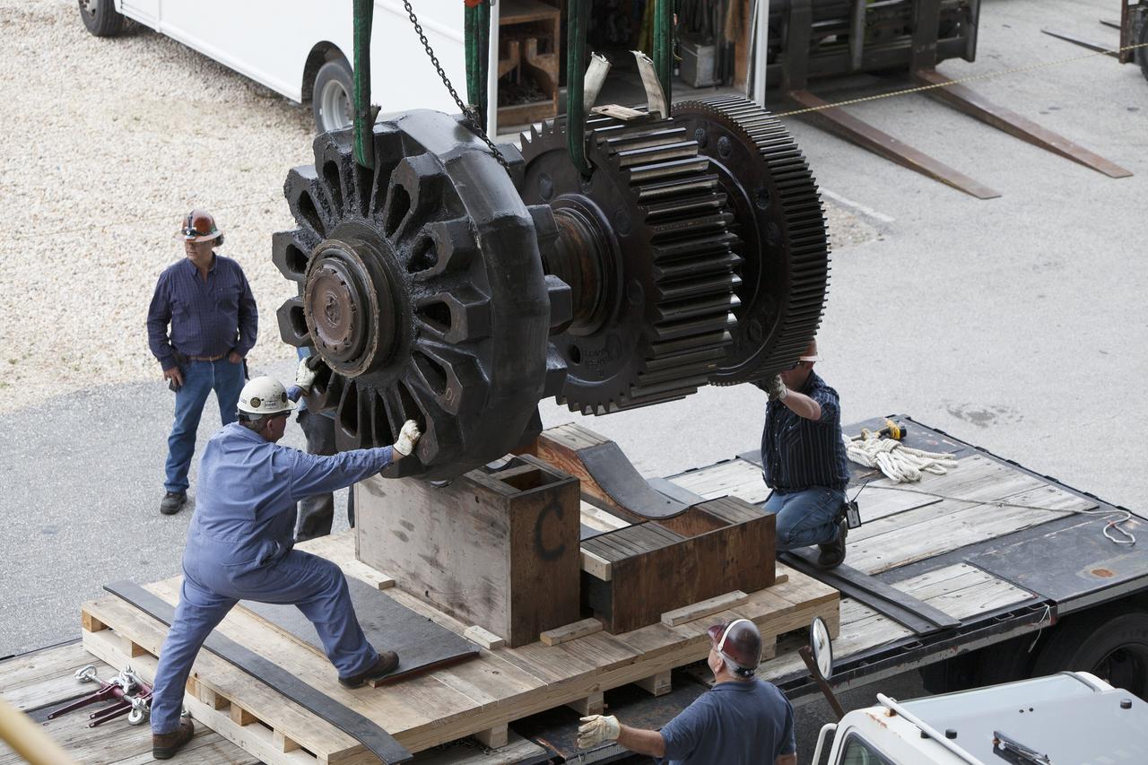 CAPE CANAVERAL, Fla. - Inside the Vehicle Assembly Building at NASA’s Kennedy Space Center in Florida, ground support technicians help position a sprocket shaft assembly onto a cradle as an overhead crane lowers it down. The sprocket assembly was removed from the C truck of crawler-transporter 2, or CT-2. They will be placed into shipping cradles on pallets and positioned on a flatbed trailer. The assemblies will be sent to a vendor for inspections and refurbishment.    Work continues in high bay 2 to upgrade CT-2. The modifications are designed to ensure CT-2’s ability to transport launch vehicles currently in development, such as the agency’s Space Launch System, to the launch pad. The Ground Systems Development and Operations Program office at Kennedy is overseeing the upgrades. For more than 45 years the crawler-transporters were used to transport the mobile launcher platform and the Apollo-Saturn V rockets and, later, space shuttles to Launch Pads 39A and B. For more information, visit: http://www.nasa.gov/exploration/systems/ground/crawler-transporter. Photo credit: NASA/Dimitri Gerondidakis