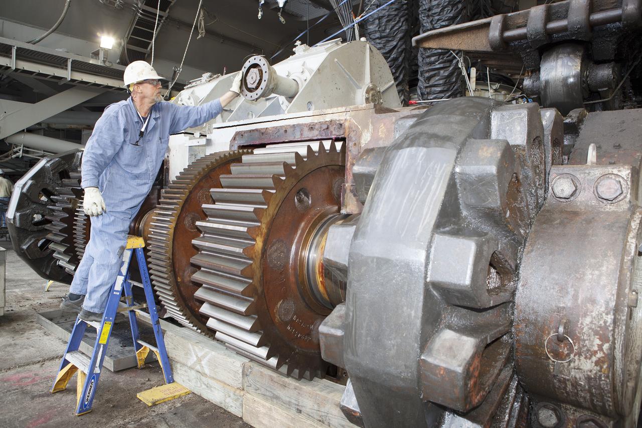 CAPE CANAVERAL, Fla. - Inside the Vehicle Assembly Building at NASA’s Kennedy Space Center in Florida, a ground support technician prepares for removal of a shaft assembly on the C truck of crawler-transporter 2, or CT-2. A section of the treads on the C truck were removed to allow access to the sprocket assemblies. The sprocket assemblies will be placed into shipping cradles on pallets and positioned on a flatbed trailer. The assemblies will be sent to a vendor for inspections and refurbishment.     Work continues in high bay 2 to upgrade CT-2. The modifications are designed to ensure CT-2’s ability to transport launch vehicles currently in development, such as the agency’s Space Launch System, to the launch pad. The Ground Systems Development and Operations Program office at Kennedy is overseeing the upgrades. For more than 45 years the crawler-transporters were used to transport the mobile launcher platform and the Apollo-Saturn V rockets and, later, space shuttles to Launch Pads 39A and B. For more information, visit: http://www.nasa.gov/exploration/systems/ground/crawler-transporter. Photo credit: NASA/Dimitri Gerondidakis