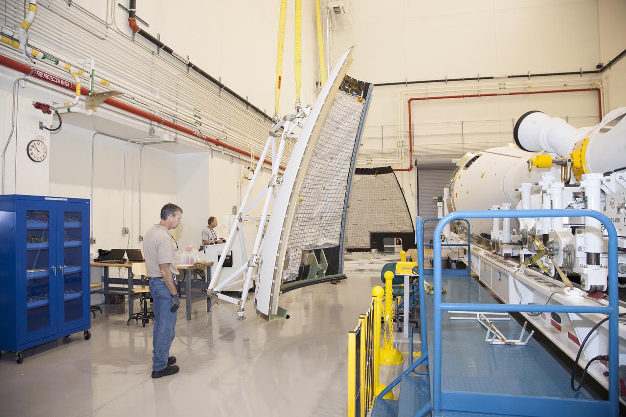 CAPE CANAVERAL, Fla. - The first set of two Ogive panels for the Orion Launch Abort System was uncrated inside the Launch Abort System Facility, or LASF, at NASA’s Kennedy Space Center in Florida. One of the panels is secured on a storage stand at the other end of the facility. Technicians monitor the progress as the second panel is being moved to join the first panel on the storage stand. To the right is the Launch Abort system secured on a work stand. During processing, the panels will be secured around the Orion crew module and attached to the Launch Abort System.    Orion is the exploration spacecraft designed to carry astronauts to destinations not yet explored by humans, including an asteroid and Mars. It will have emergency abort capability, sustain the crew during space travel and provide safe re-entry from deep space return velocities. The first unpiloted test flight of Orion is scheduled to launch in 2014 atop a Delta IV rocket and in 2017 on NASA’s Space Launch System rocket. For more information, visit www.nasa.gov/orion. Photo credit: Dan Casper