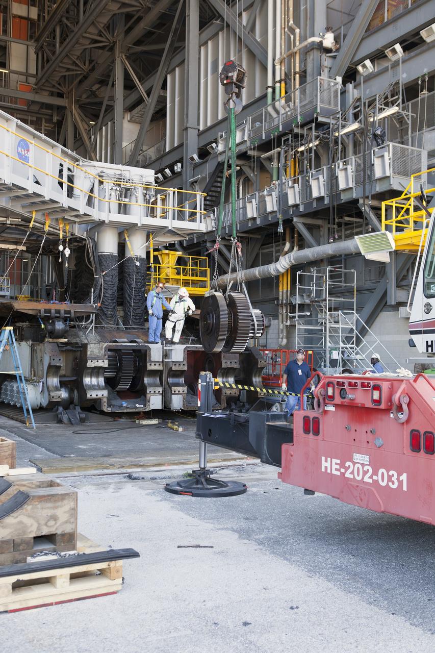 CAPE CANAVERAL, Fla. -- Inside the Vehicle Assembly Building at NASA’s Kennedy Space Center in Florida, ground support technicians prepare one of the sprocket shaft assemblies on the C truck of crawler-transporter 2, or CT-2 for removal. The sprocket assemblies will be placed into shipping cradles on pallets and positioned on a flatbed trailer. They will be sent to a vendor for inspections and refurbishment.    Work continues in high bay 2 to upgrade CT-2. The modifications are designed to ensure CT-2’s ability to transport launch vehicles currently in development, such as the agency’s Space Launch System, to the launch pad. The Ground Systems Development and Operations Program office at Kennedy is overseeing the upgrades. For more than 45 years the crawler-transporters were used to transport the mobile launcher platform and the Apollo-Saturn V rockets and, later, space shuttles to Launch Pads 39A and B. For more information, visit: http://www.nasa.gov/exploration/systems/ground/crawler-transporter. Photo credit: NASA/Dimitri Gerondidakis