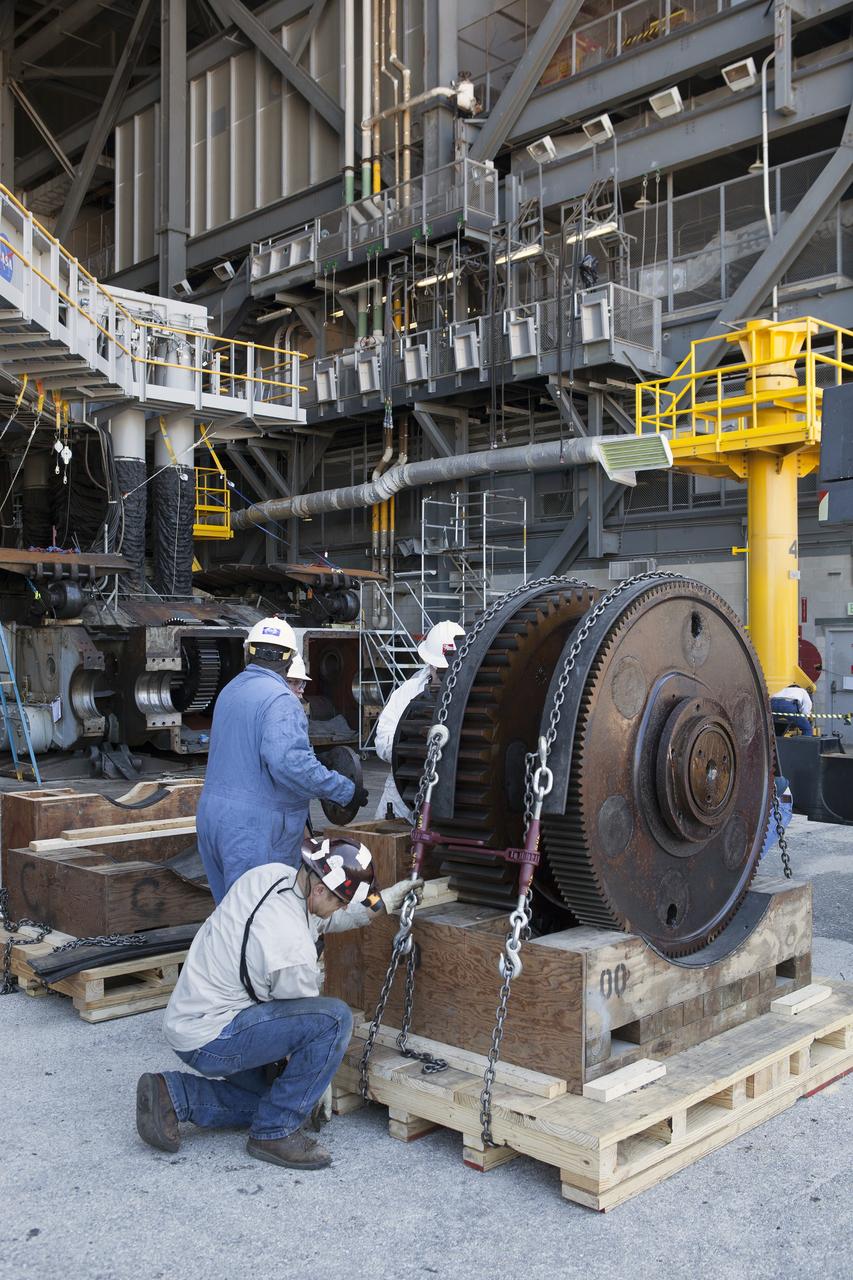 CAPE CANAVERAL, Fla. -- Inside the Vehicle Assembly Building at NASA’s Kennedy Space Center in Florida, ground support technicians help secure one of the sprocket shaft assemblies onto a cradle. All of the sprocket assemblies removed from the C truck of crawler-transporter 2, or CT-2, will be placed into shipping cradles on pallets and positioned on a flatbed trailer. They will be sent to a vendor for inspections and refurbishment.    Work continues in high bay 2 to upgrade CT-2. The modifications are designed to ensure CT-2’s ability to transport launch vehicles currently in development, such as the agency’s Space Launch System, to the launch pad. The Ground Systems Development and Operations Program office at Kennedy is overseeing the upgrades. For more than 45 years the crawler-transporters were used to transport the mobile launcher platform and the Apollo-Saturn V rockets and, later, space shuttles to Launch Pads 39A and B. For more information, visit: http://www.nasa.gov/exploration/systems/ground/crawler-transporter. Photo credit: NASA/Dimitri Gerondidakis