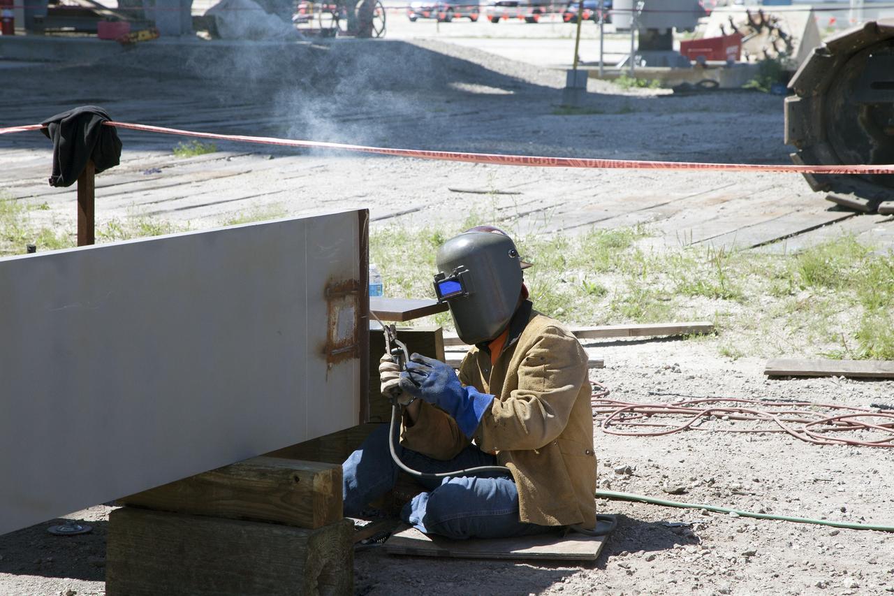 CAPE CANAVERAL, Fla. -- Modifications continue on the Mobile Launcher, or ML, at the Mobile Launcher Park Site at NASA’s Kennedy Space Center in Florida. A construction worker performs welding work on a section of steel for the exterior of the ML.     In 2013, the agency awarded a contract to J.P. Donovan Construction Inc. of Rockledge, Fla., to modify the ML, which is one of the key elements of ground support equipment that is being upgraded by the Ground Systems Development and Operations Program office at Kennedy. The ML will carry the SLS rocket and Orion spacecraft to Launch Pad 39B for its first mission, Exploration Mission 1, in 2017. Photo credit: NASA/Daniel Casper