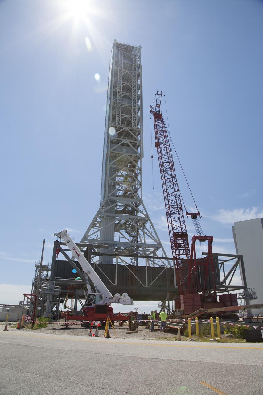 CAPE CANAVERAL, Fla. -- Modifications continue on the Mobile Launcher, or ML, at the Mobile Launcher Park Site at NASA’s Kennedy Space Center in Florida. Two large cranes are situated next to the ML for lifting of heavy metal beams and other construction materials.    In 2013, the agency awarded a contract to J.P. Donovan Construction Inc. of Rockledge, Fla., to modify the ML, which is one of the key elements of ground support equipment that is being upgraded by the Ground Systems Development and Operations Program office at Kennedy. The ML will carry the SLS rocket and Orion spacecraft to Launch Pad 39B for its first mission, Exploration Mission 1, in 2017. Photo credit: NASA/Daniel Casper