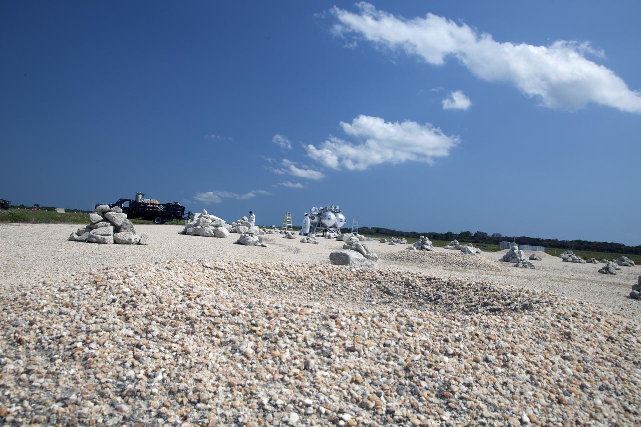 CAPE CANAVERAL, Fla. – NASA's Project Morpheus prototype lander is being prepared for a free flight test from a new launch pad at the north end of the Shuttle Landing Facility at NASA's Kennedy Space Center in Florida. The 98-second test began at 3:20 p.m. EDT with the Morpheus lander launching from the ground over a flame trench and ascending more than 800 feet at a peak speed of 36 mph. The vehicle, with its recently installed autonomous landing and hazard avoidance technology ALHAT sensors, surveyed the hazard field to determine safe landing sites. Morpheus then flew forward and downward covering approximately 1300 feet while performing a 78-foot divert to simulate a hazard avoidance maneuver. The lander then descended and landed on a dedicated pad inside the autonomous landing and hazard avoidance technology hazard field. Project Morpheus tests NASA’s ALHAT and an engine that runs on liquid oxygen and methane, which are green propellants. These new capabilities could be used in future efforts to deliver cargo to planetary surfaces.     The landing facility provides the lander with the kind of field necessary for realistic testing, complete with rocks, craters and hazards to avoid. Morpheus’ ALHAT payload allows it to navigate to clear landing sites amidst rocks, craters and other hazards during its descent. Project Morpheus is being managed under the Advanced Exploration Systems, or AES, Division in NASA’s Human Exploration and Operations Mission Directorate. The efforts in AES pioneer new approaches for rapidly developing prototype systems, demonstrating key capabilities and validating operational concepts for future human missions beyond Earth orbit. For more information on Project Morpheus, visit http://morpheuslander.jsc.nasa.gov/.  Photo credit: NASA/Daniel Casper