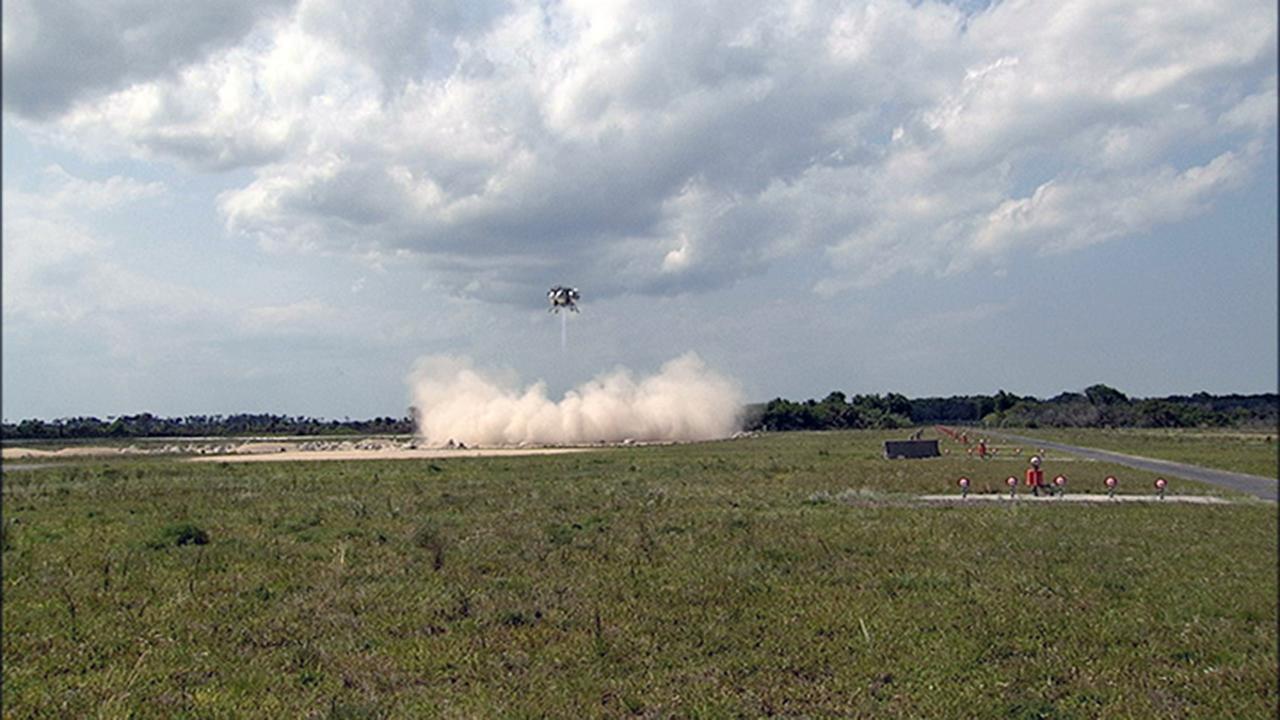 CAPE CANAVERAL, Fla. – NASA's Project Morpheus prototype lander descends toward the autonomous landing and hazard avoidance field after a free-flight test from a new launch pad at the north end of the Shuttle Landing Facility at NASA's Kennedy Space Center in Florida. The 98-second test began at 3:20 p.m. EDT with the Morpheus lander launching from the ground over a flame trench and ascending more than 800 feet at a peak speed of 36 mph. The vehicle, with its recently installed autonomous landing and hazard avoidance technology ALHAT sensors, surveyed the hazard field to determine safe landing sites. Morpheus then flew forward and downward covering approximately 1300 feet while performing a 78-foot divert to simulate a hazard avoidance maneuver. The lander then descended and landed on a dedicated pad inside the autonomous landing and hazard avoidance technology hazard field. Project Morpheus tests NASA’s ALHAT and an engine that runs on liquid oxygen and methane, which are green propellants. These new capabilities could be used in future efforts to deliver cargo to planetary surfaces.     The landing facility provides the lander with the kind of field necessary for realistic testing, complete with rocks, craters and hazards to avoid. Morpheus’ ALHAT payload allows it to navigate to clear landing sites amidst rocks, craters and other hazards during its descent. Project Morpheus is being managed under the Advanced Exploration Systems, or AES, Division in NASA’s Human Exploration and Operations Mission Directorate. The efforts in AES pioneer new approaches for rapidly developing prototype systems, demonstrating key capabilities and validating operational concepts for future human missions beyond Earth orbit. For more information on Project Morpheus, visit http://morpheuslander.jsc.nasa.gov/.  Photo credit: NASA/Chris Chamberland