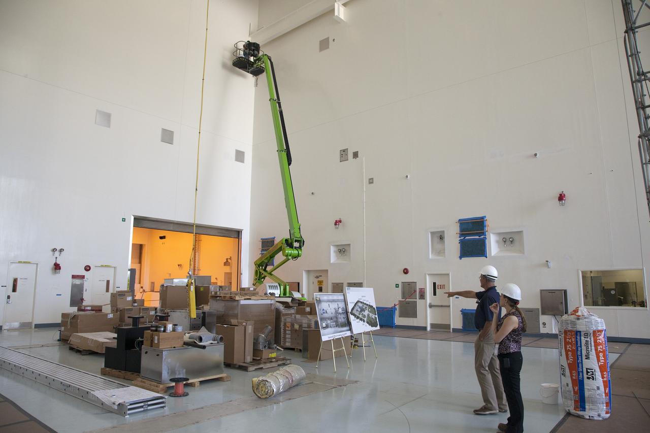 CAPE CANAVERAL, Fla. – Modifications continue on the Multi-Payload Processing Facility, or MPPF, at NASA's Kennedy Space Center in Florida. Inside the high bay, Skip Williams, Ground Systems Development and Operations, or GSDO, deputy project manager for the spacecraft offline element integration team, points out artist illustrations of how the MPPF's interior and exterior will look after modifications and upgrades have been completed.    Kennedy's Center Operations Directorate is overseeing upgrades to the MPPF for GSDO Program. The extensive upgrades and modernizations will support processing of Orion spacecraft for NASA's exploration missions. The 19,647-square-foot building, originally constructed in 1995, primarily will be used for Orion hypergolic fueling, ammonia servicing and high-pressure gas servicing and checkout before being transported to the Vehicle Assembly Building for integration with the Space Launch System. Photo credit: NASA/Daniel Casper