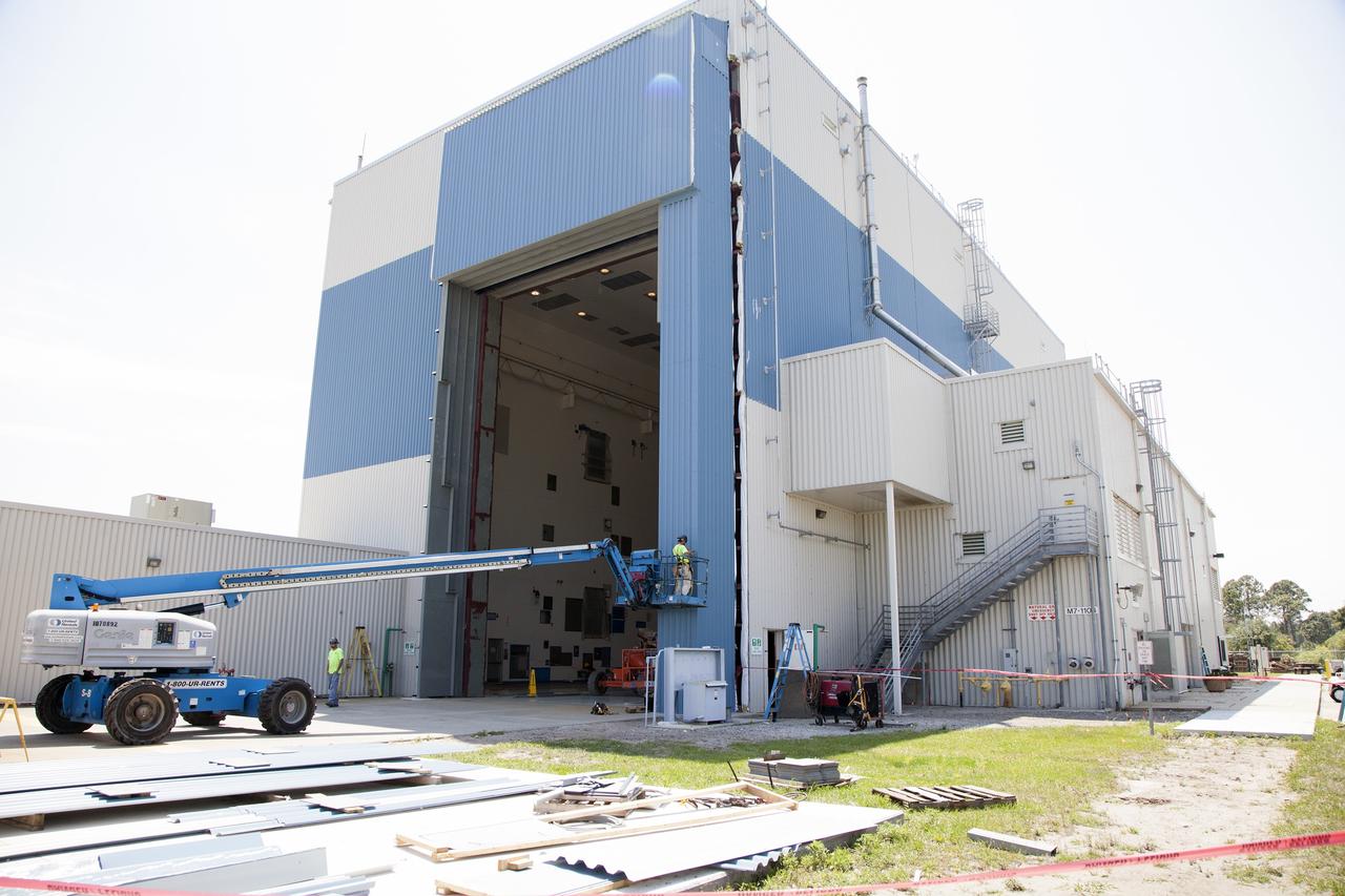 CAPE CANAVERAL, Fla. – Modifications continue on the Multi-Payload Processing Facility, or MPPF, at NASA's Kennedy Space Center in Florida. The high bay entrance was recently enlarged and a new door installed. Construction workers are installing new siding around the entrance.    Kennedy's Center Operations Directorate is overseeing upgrades to the MPPF for the Ground Systems Development and Operations Program. The extensive upgrades and modernizations will support processing of Orion spacecraft for NASA's exploration missions. The 19,647-square-foot building, originally constructed in 1995, primarily will be used for Orion hypergolic fueling, ammonia servicing and high-pressure gas servicing and checkout before being transported to the Vehicle Assembly Building for integration with the Space Launch System. Photo credit: NASA/Daniel Casper