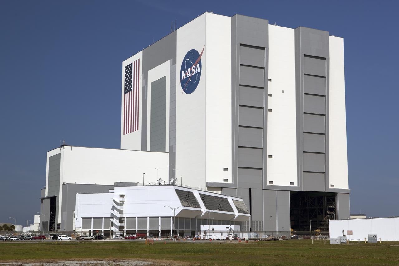 CAPE CANAVERAL, Fla. – The Vehicle Assembly Building and Launch Control Center are contrasted against a blue sky at NASA's Kennedy Space Center in Florida. Inside Firing Room 4, the Ground Systems Development and Operations Program is overseeing efforts to create a new firing room based on a multi-user concept. Construction workers have installed the framing and some of the insulation and inner walls.     The design of Firing Room 4 will incorporate five control room areas that are flexible to meet current and future NASA and commercial user requirements. The equipment and most of the consoles from Firing Room 4 were moved to Firing Room 2 for possible future reuse. Photo credit: NASA/Dimitri Gerondidakis