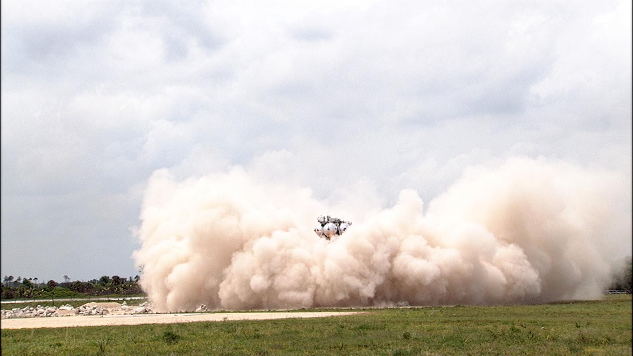 CAPE CANAVERAL, Fla. – NASA's Project Morpheus prototype lander descends toward the autonomous landing and hazard avoidance technology, or ALHAT, field after lifting off on a free-flight test from a new launch pad at the north end of the Shuttle Landing Facility at NASA's Kennedy Space Center in Florida. The 98-second test began at 1:57 p.m. EDT with the Morpheus lander launching from the ground over a flame trench and ascending more than 800 feet at a peak speed of 36 mph. The vehicle, with its recently installed ALHAT sensors, surveyed the hazard field to determine safe landing sites. Morpheus then flew forward and downward covering approximately 1300 feet while performing a 78-foot divert to simulate a hazard avoidance maneuver. The lander descended and landed on a dedicated pad inside the ALHAT hazard field. Project Morpheus tests NASA’s ALHAT and an engine that runs on liquid oxygen and methane, which are green propellants. These new capabilities could be used in future efforts to deliver cargo to planetary surfaces.    The landing facility provides the lander with the kind of field necessary for realistic testing, complete with rocks, craters and hazards to avoid. Morpheus’ ALHAT payload allows it to navigate to clear landing sites amidst rocks, craters and other hazards during its descent. Project Morpheus is being managed under the Advanced Exploration Systems, or AES, Division in NASA’s Human Exploration and Operations Mission Directorate. The efforts in AES pioneer new approaches for rapidly developing prototype systems, demonstrating key capabilities and validating operational concepts for future human missions beyond Earth orbit. For more information on Project Morpheus, visit http://morpheuslander.jsc.nasa.gov/.  Photo credit: NASA/Frankie Martin