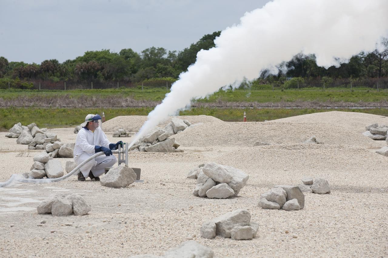 CAPE CANAVERAL, Fla. – A technician vents off the gas from the propellant lines of NASA's Project Morpheus prototype lander after it landed from a free-flight test at the north end of the Shuttle Landing Facility at NASA's Kennedy Space Center in Florida. The 98-second test began at 1:57 p.m. EDT with the Morpheus lander launching from the ground over a flame trench and ascending more than 800 feet at a peak speed of 36 mph. The vehicle, with its recently installed autonomous landing and hazard avoidance technology, or ALHAT, sensors surveyed the hazard field to determine safe landing sites. Morpheus then flew forward and downward covering approximately 1300 feet while performing a 78-foot divert to simulate a hazard avoidance maneuver. The lander descended and landed on a dedicated pad inside the ALHAT hazard field. Project Morpheus tests NASA’s ALHAT and an engine that runs on liquid oxygen and methane, which are green propellants. These new capabilities could be used in future efforts to deliver cargo to planetary surfaces. The landing facility provides the lander with the kind of field necessary for realistic testing, complete with rocks, craters and hazards to avoid. Morpheus’ ALHAT payload allows it to navigate to clear landing sites amidst rocks, craters and other hazards during its descent. Project Morpheus is being managed under the Advanced Exploration Systems, or AES, Division in NASA’s Human Exploration and Operations Mission Directorate. The efforts in AES pioneer new approaches for rapidly developing prototype systems, demonstrating key capabilities and validating operational concepts for future human missions beyond Earth orbit. For more information on Project Morpheus, visit http://morpheuslander.jsc.nasa.gov/. Photo credit: NASA/Kim Shiflett
