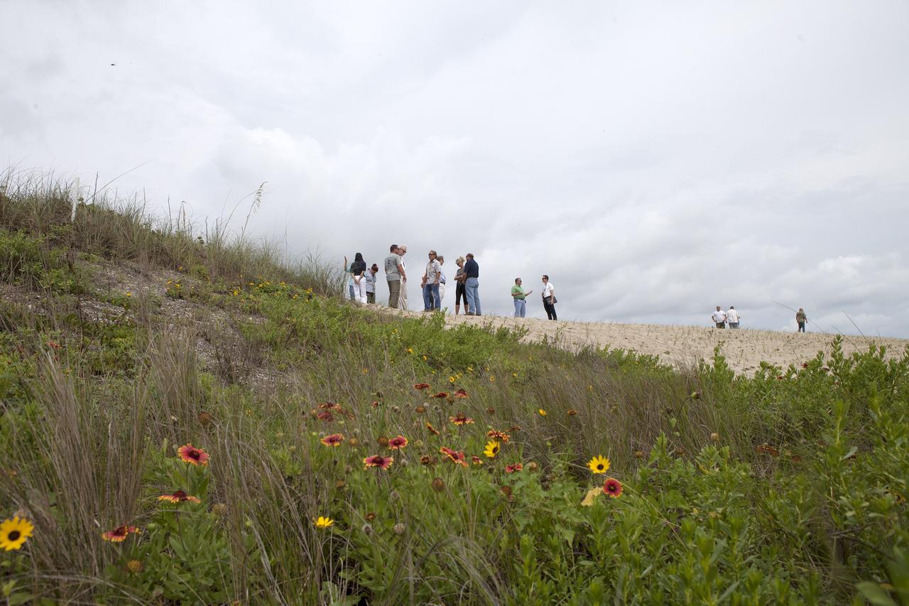 CAPE CANAVERAL, Fla. -- At the Kennedy Space Center in Florida, guests survey restored sand dunes along a 1.2-mile stretch of shoreline near Launch Pads 39A and B.      Constant pounding from tropical storms, such as Hurricane Sandy in October of 2012, other weather systems and higher than usual tides, destroyed sand dunes protecting infrastructure at the spaceport. Photo credit: NASA/Dan Casper