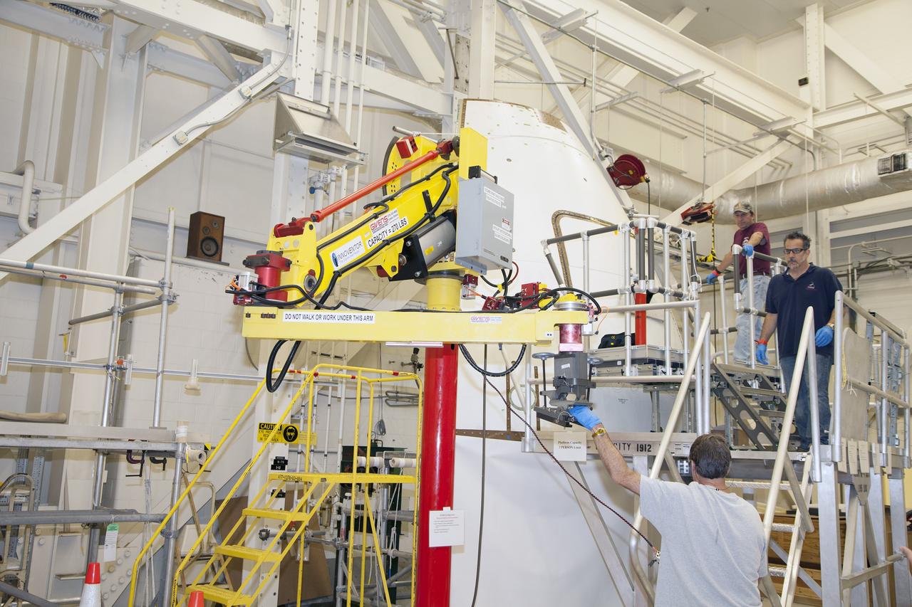 CAPE CANAVERAL, Fla. – Inside the Vehicle Assembly Building at NASA’s Kennedy Space Center in Florida, engineers and technicians prepare the ground test article Launch Abort System, or LAS, ogive panel and an Orion crew module simulator for a GIZMO demonstration test. A technician moves the GIZMO, a pneumatically-balanced manipulator that will be used for installation of the crew module and LAS flight hatches for the uncrewed Exploration Flight Test-1 and Exploration Mission-1, toward the mockup. The Ground Systems Development and Operations Program is running the test to demonstrate that the GIZMO can meet the reach and handling requirements for the task.    Orion is the exploration spacecraft designed to carry astronauts to destinations not yet explored by humans, including an asteroid and Mars. It will have emergency abort capability, sustain the crew during space travel and provide safe re-entry from deep space return velocities. The first unpiloted test flight of the Orion is scheduled to launch later this year atop a Delta IV rocket and in 2017 on NASA’s Space Launch System rocket. For more information, visit http://www.nasa.gov/orion. Photo credit: NASA/Daniel Casper