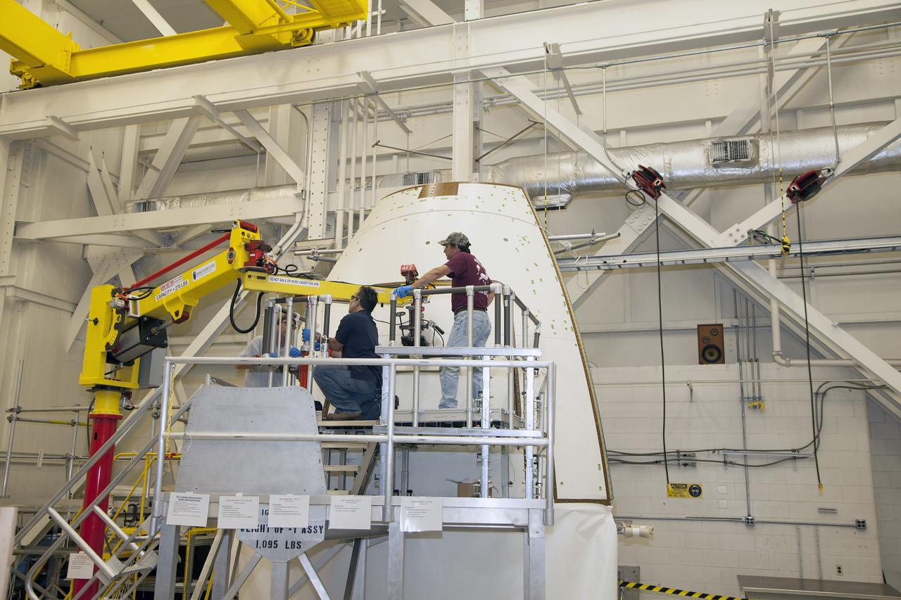 CAPE CANAVERAL, Fla. – Inside the Vehicle Assembly Building at NASA’s Kennedy Space Center in Florida, engineers and technicians have prepared the ground test article Launch Abort System, or LAS, ogive panel and an Orion crew module simulator for a GIZMO demonstration test. A technician moves the GIZMO, a pneumatically-balanced manipulator that will be used for installation of the crew module and LAS flight hatches for the uncrewed Exploration Flight Test-1 and Exploration Mission-1, toward the mockup. The Ground Systems Development and Operations Program is running the test to demonstrate that the GIZMO can meet the reach and handling requirements for the task.     Orion is the exploration spacecraft designed to carry astronauts to destinations not yet explored by humans, including an asteroid and Mars. It will have emergency abort capability, sustain the crew during space travel and provide safe re-entry from deep space return velocities. The first unpiloted test flight of the Orion is scheduled to launch later this year atop a Delta IV rocket and in 2017 on NASA’s Space Launch System rocket. For more information, visit http://www.nasa.gov/orion. Photo credit: NASA/Daniel Casper